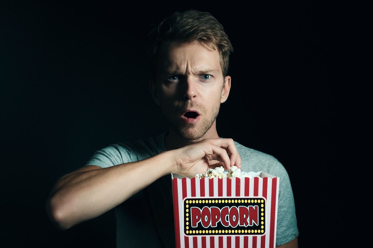 Mann schaut Horrorfilm mit Angst