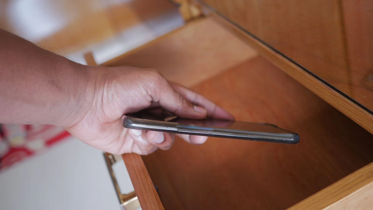 steals the smartphone from a drawer
