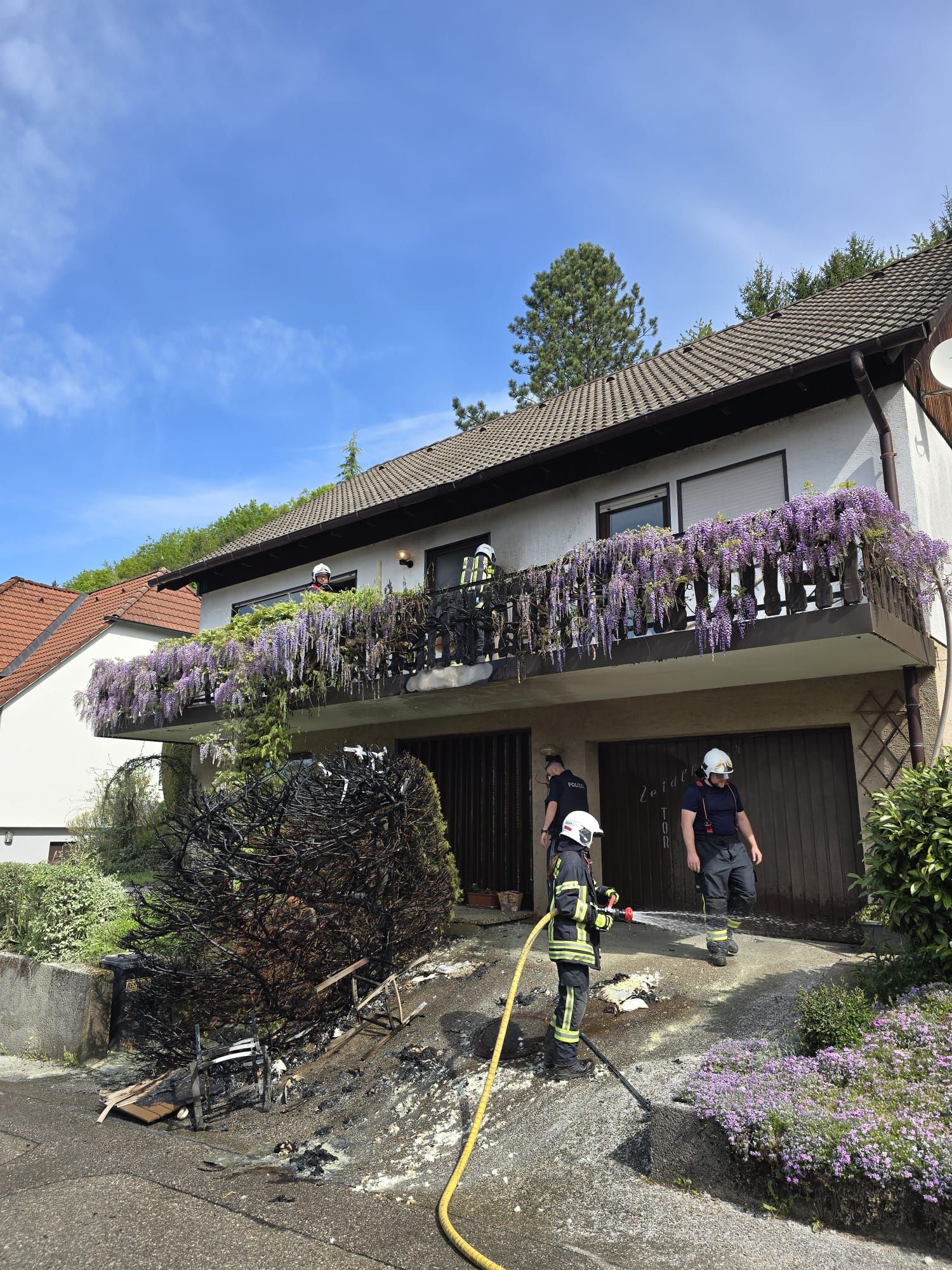 Ein Feuerwehrmann ist als Passant unterwegs, als er die brennende Hecke entdeckt.