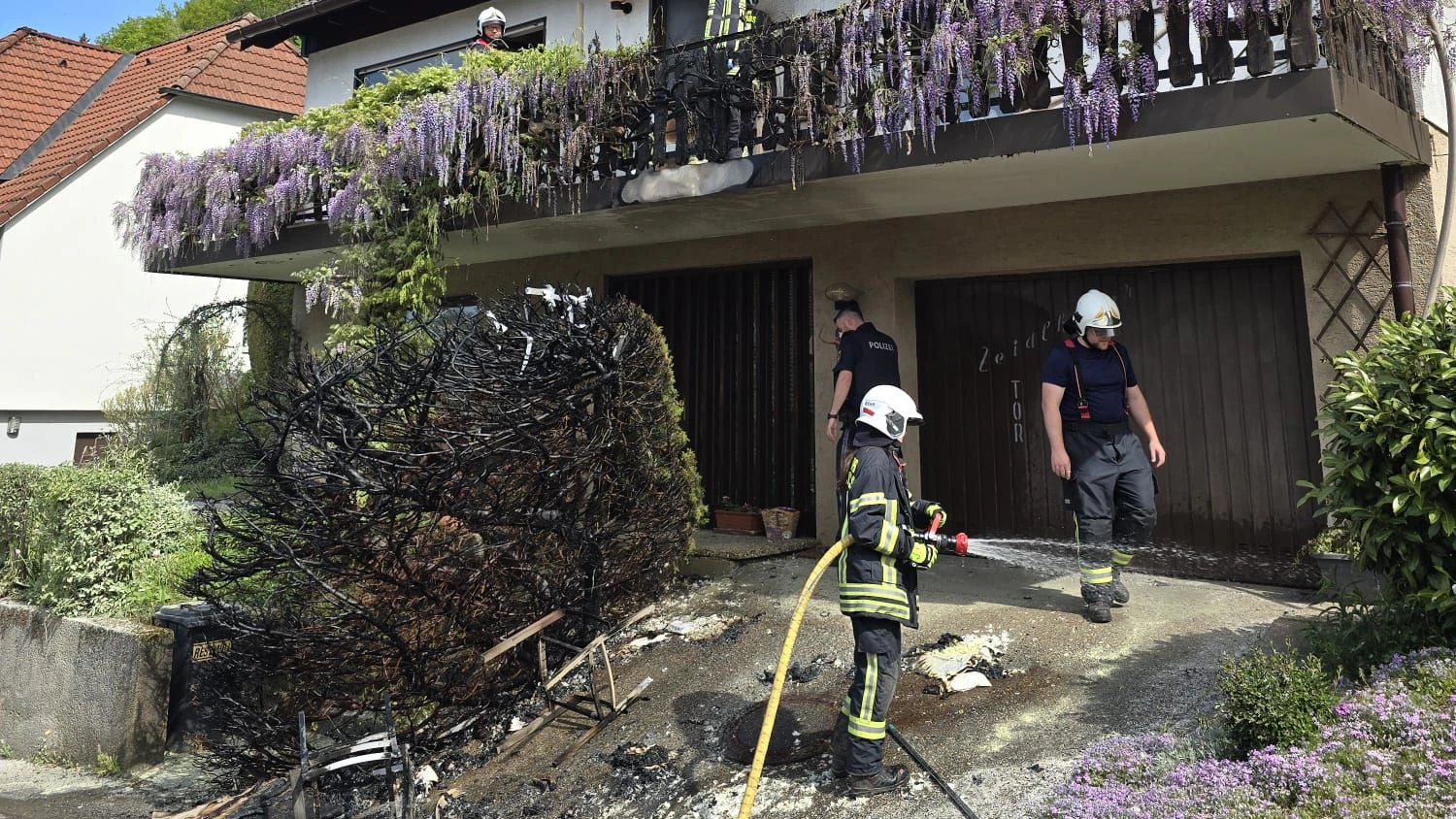 Ein Feuerwehrmann ist als Passant unterwegs, als er die brennende Hecke entdeckt.