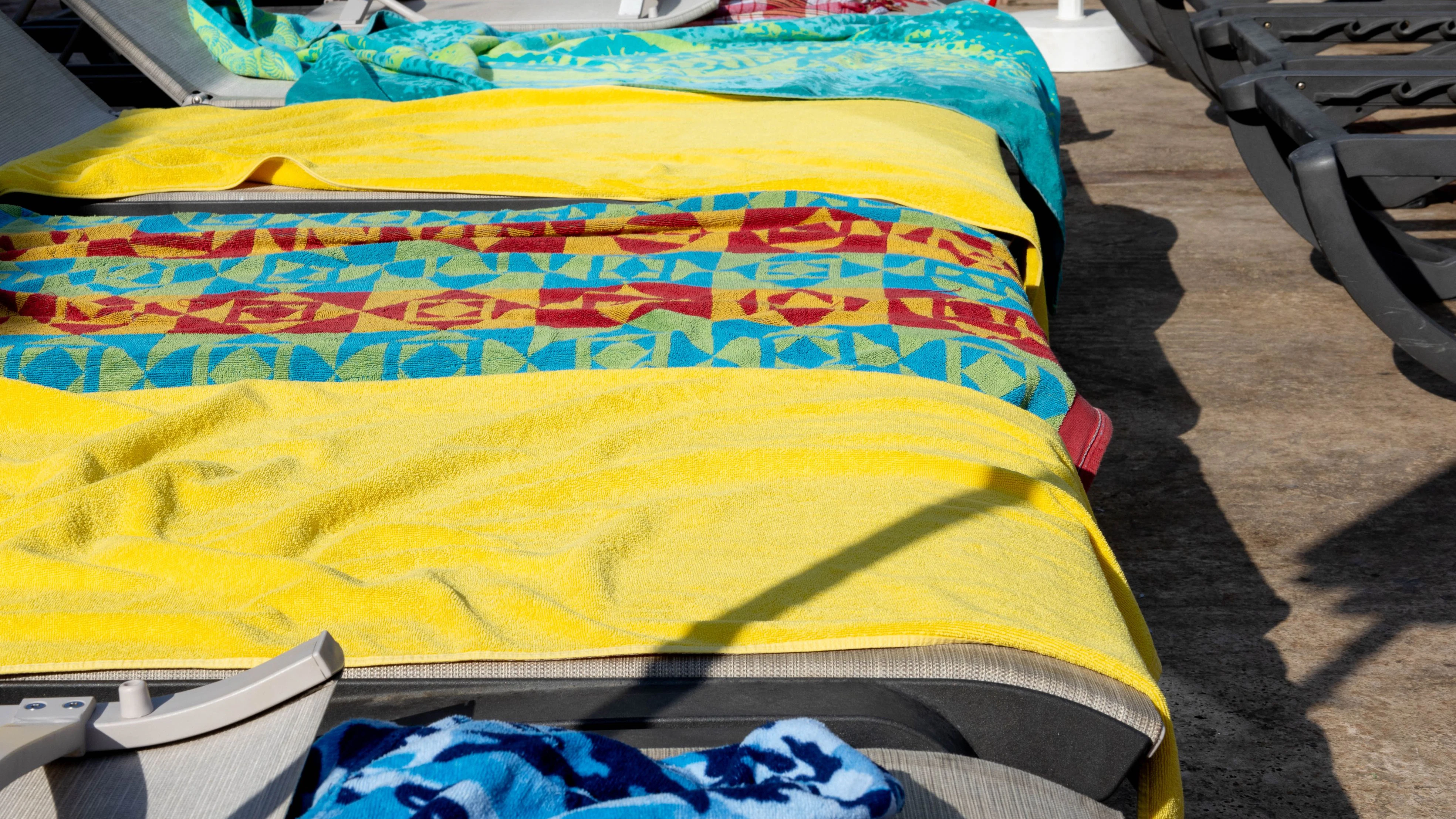 Put down towels to reserve sunbeds at the pool area