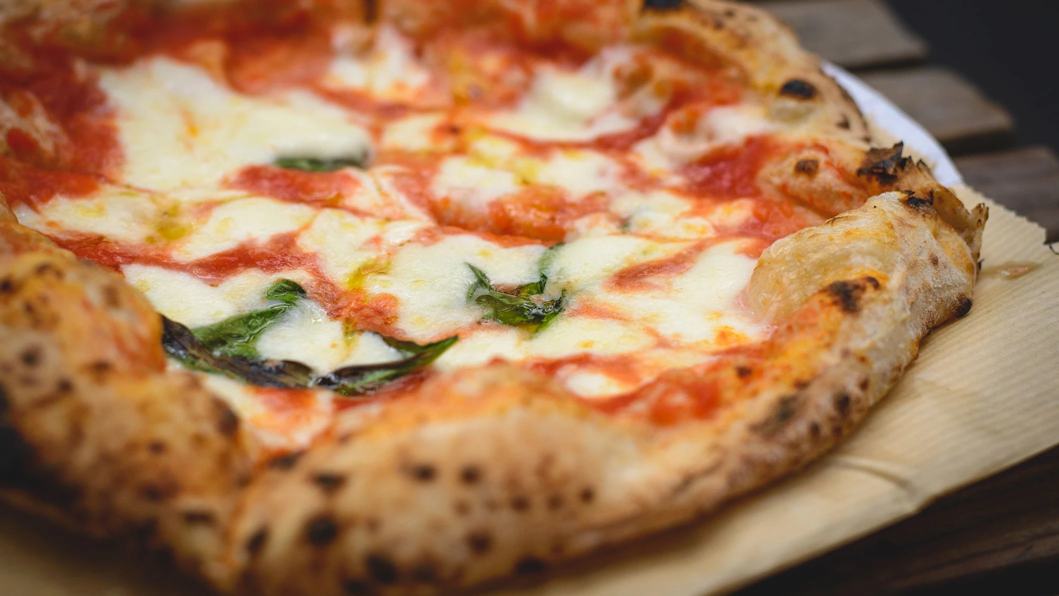 Close up view of a Margherita Neapolitan style pizza with buffalo mozzarella, tomato sauce and basil. Landscape format.