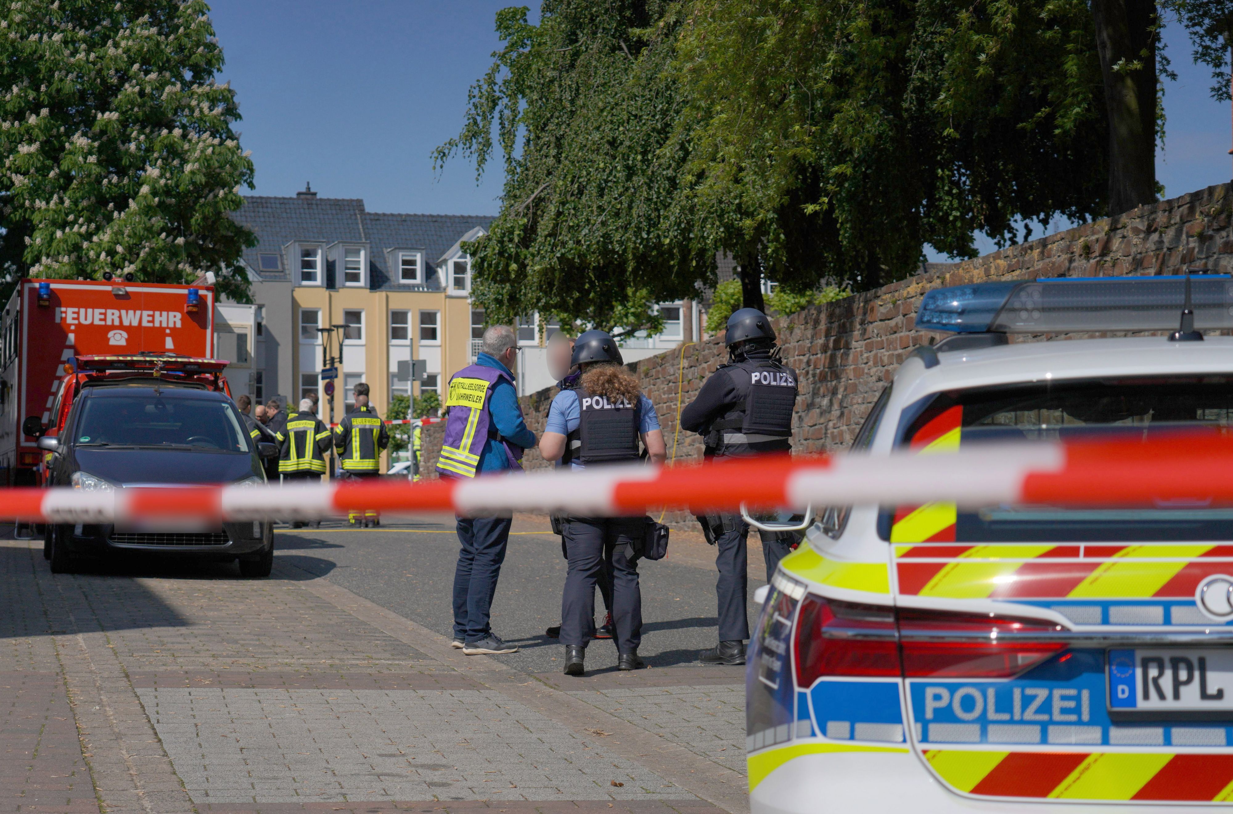 Rheinland-Pfalz, Sinzig: Polizeibeamte und Polizeifahrzeuge hinter einem Absperrband nachdem es in einer Bankfiliale zu einer Geiselnahme gekommen ist. (8. Mai 2026)