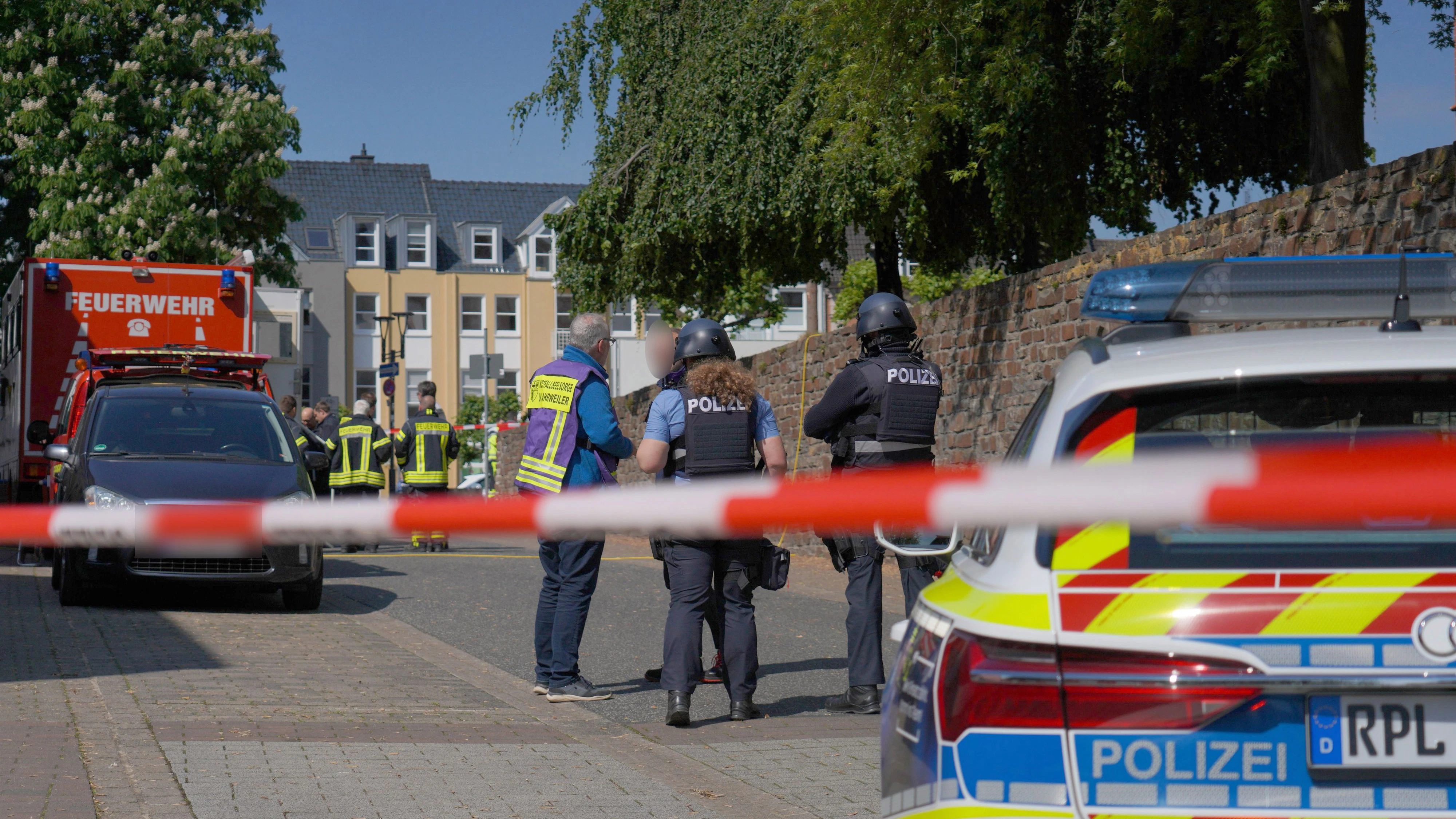 Rheinland-Pfalz, Sinzig: Polizeibeamte und Polizeifahrzeuge hinter einem Absperrband nachdem es in einer Bankfiliale zu einer Geiselnahme gekommen ist. (8. Mai 2026)
