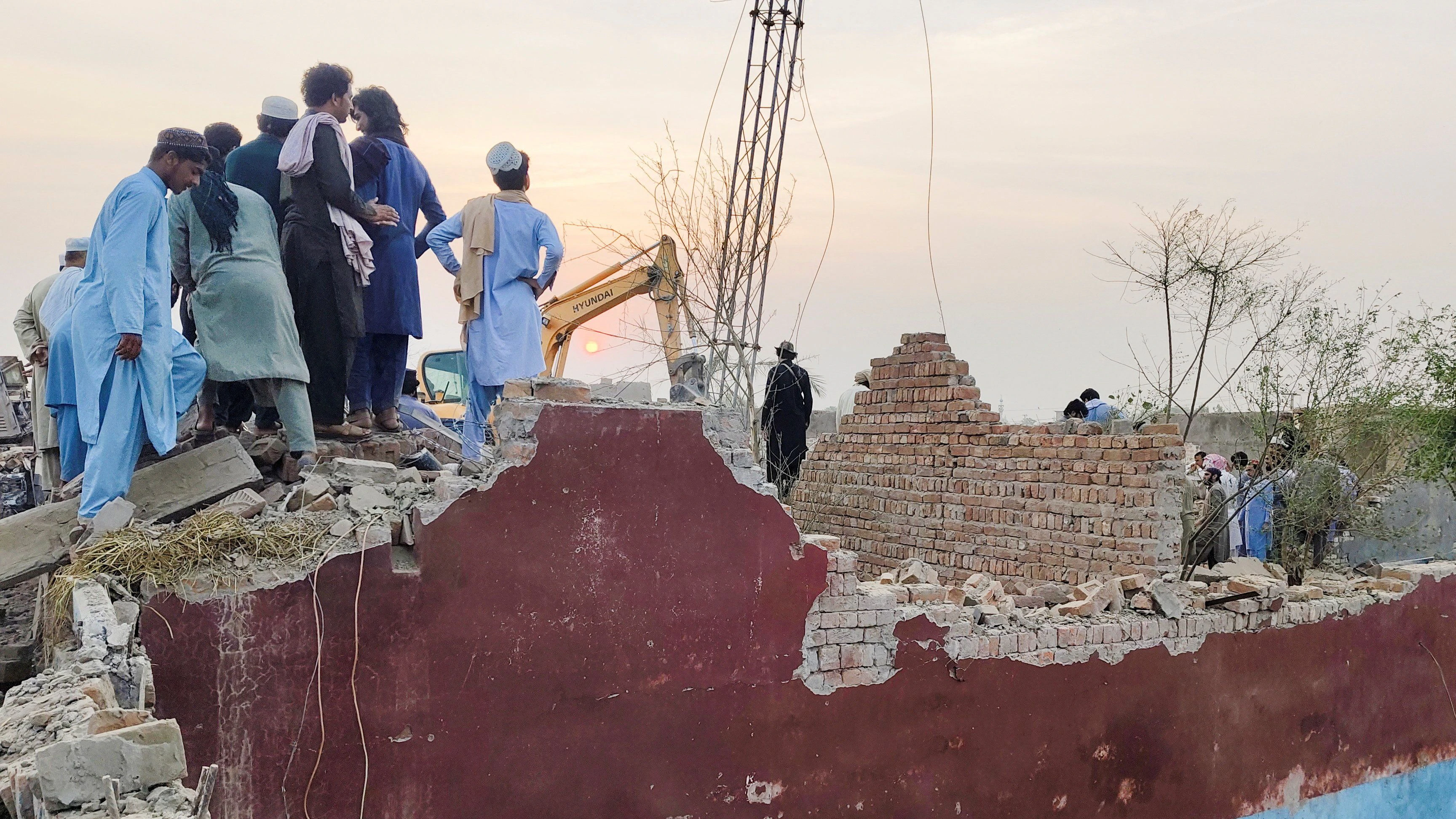 Residents gather on the rubble of a damaged police post after a car bombing in Bannu, Khyber Pakhtunkhwa province, Pakistan May 10, 2026. Picture taken with a mobile phone. REUTERS/Ehsan Khattak