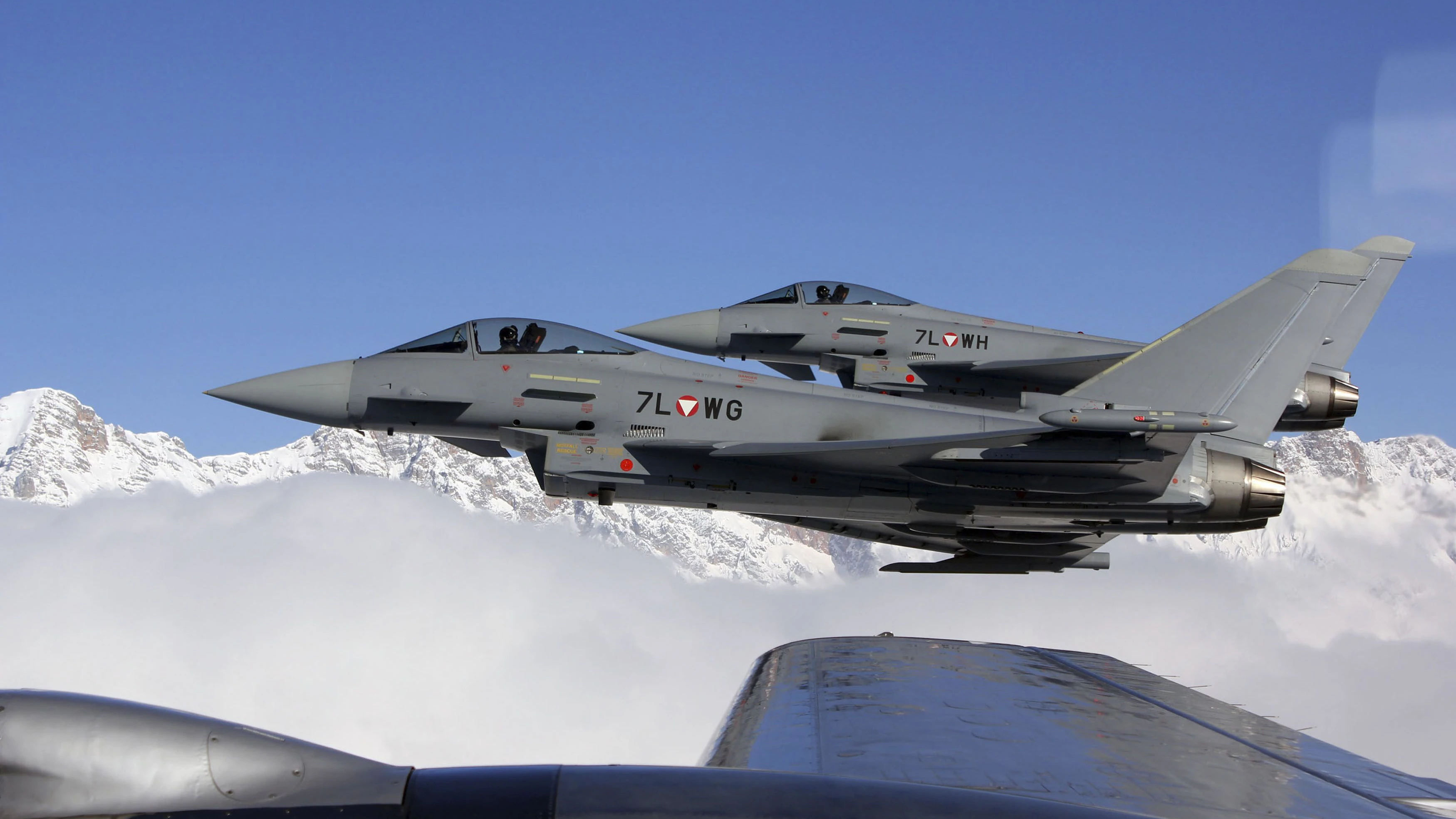 Two Eurofighter Typhoon planes of the Austrian Flying forces pass by a DC3 plane as a side event during the FIS Alpine Ski World Cup Hahnenkamm race, in area of Kitzbuehel, January 23, 2011.   REUTERS/Gerd Markhardter/Handout  (AUSTRIA - Tags: TRANSPORT SOCIETY SPORT SKIING) NO SALES. FOR EDITORIAL USE ONLY. NOT FOR SALE FOR MARKETING OR ADVERTISING CAMPAIGNS. THIS IMAGE HAS BEEN SUPPLIED BY A THIRD PARTY. IT IS DISTRIBUTED, EXACTLY AS RECEIVED BY REUTERS, AS A SERVICE TO CLIENTS