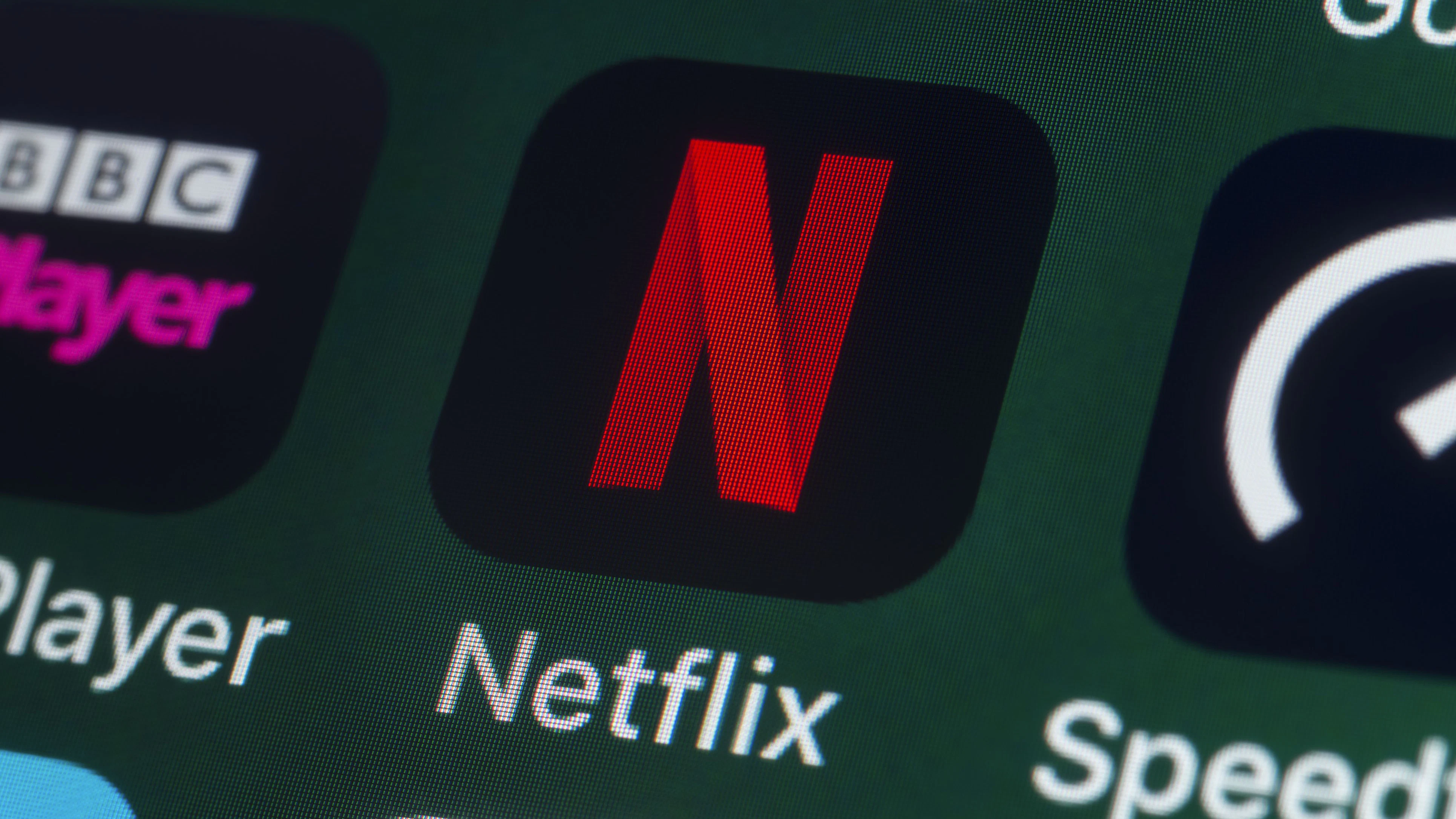London, UK - July 31, 2018: The buttons of the streaming app Netflix, surrounded by BBC iPlayer, Speedtest, News and other apps on the screen of an iPhone.