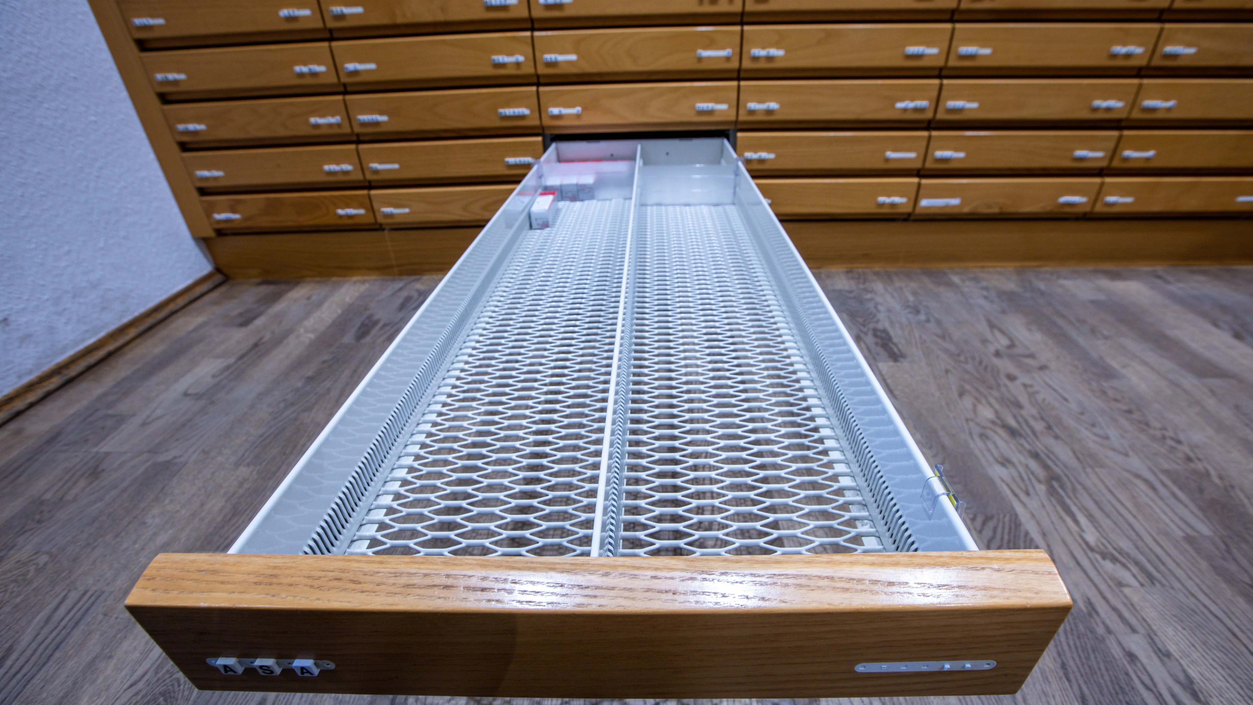PRODUCTION - 30 May 2023, Mecklenburg-Western Pomerania, Schwerin: An empty drawer in which prescription nasal drops are otherwise stored in a pharmacy cabinet at the Rainbow Pharmacy. Around a third of people in Germany have recently experienced problems when buying medicines. This is the result of a survey commissioned by the German Association of Pharmaceutical Manufacturers. According to the survey, 35 percent of respondents have experienced difficulties or shortages when buying medicines in the past twelve months. Photo: Jens Büttner/dpa