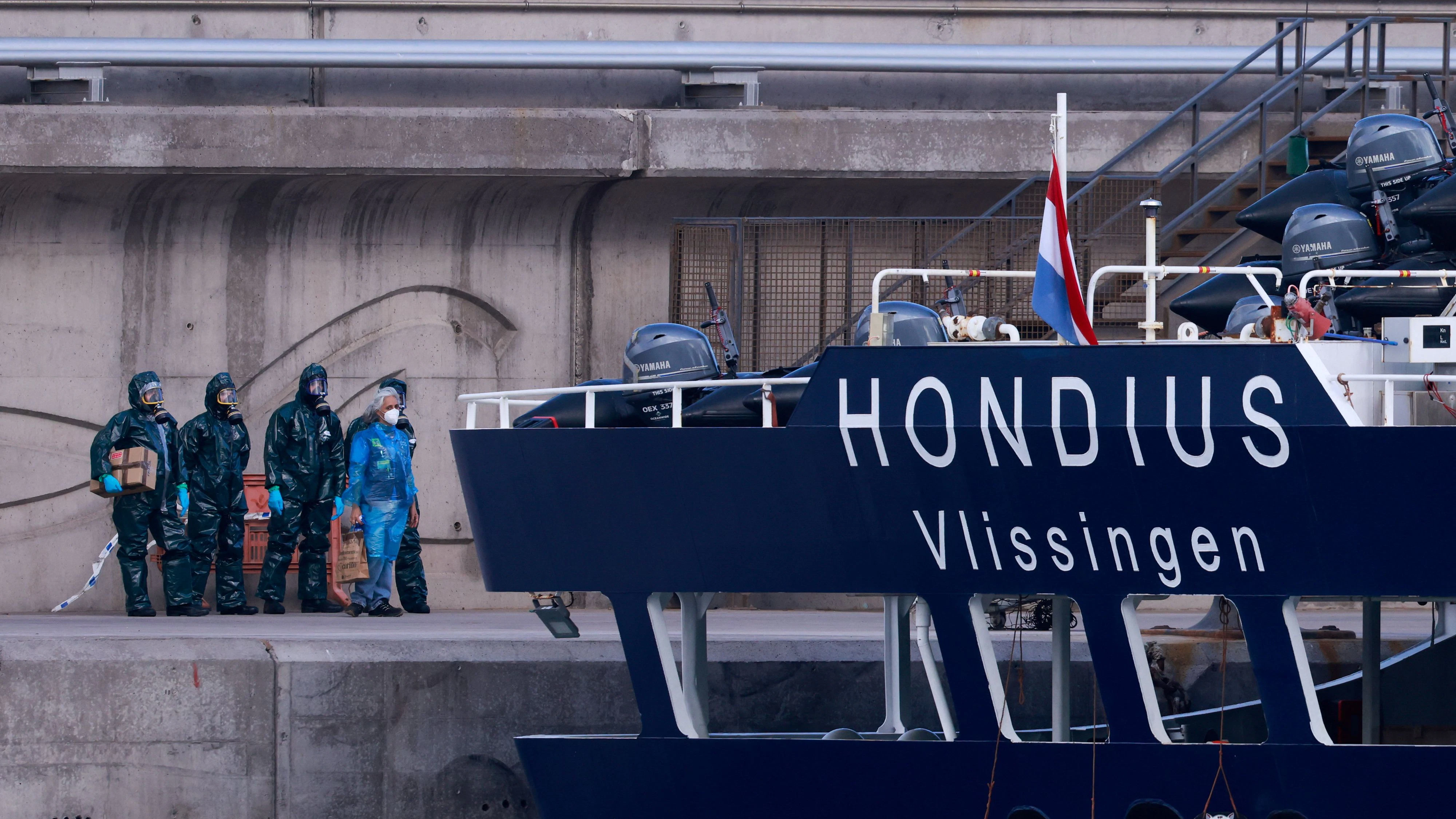 People in hazmat suits and PPE stand near the cruise ship MV Hondius, affected by a hantavirus outbreak, after it docked at the port of Granadilla de Abona, Tenerife, Spain May 11, 2026. REUTERS/Borja Suarez