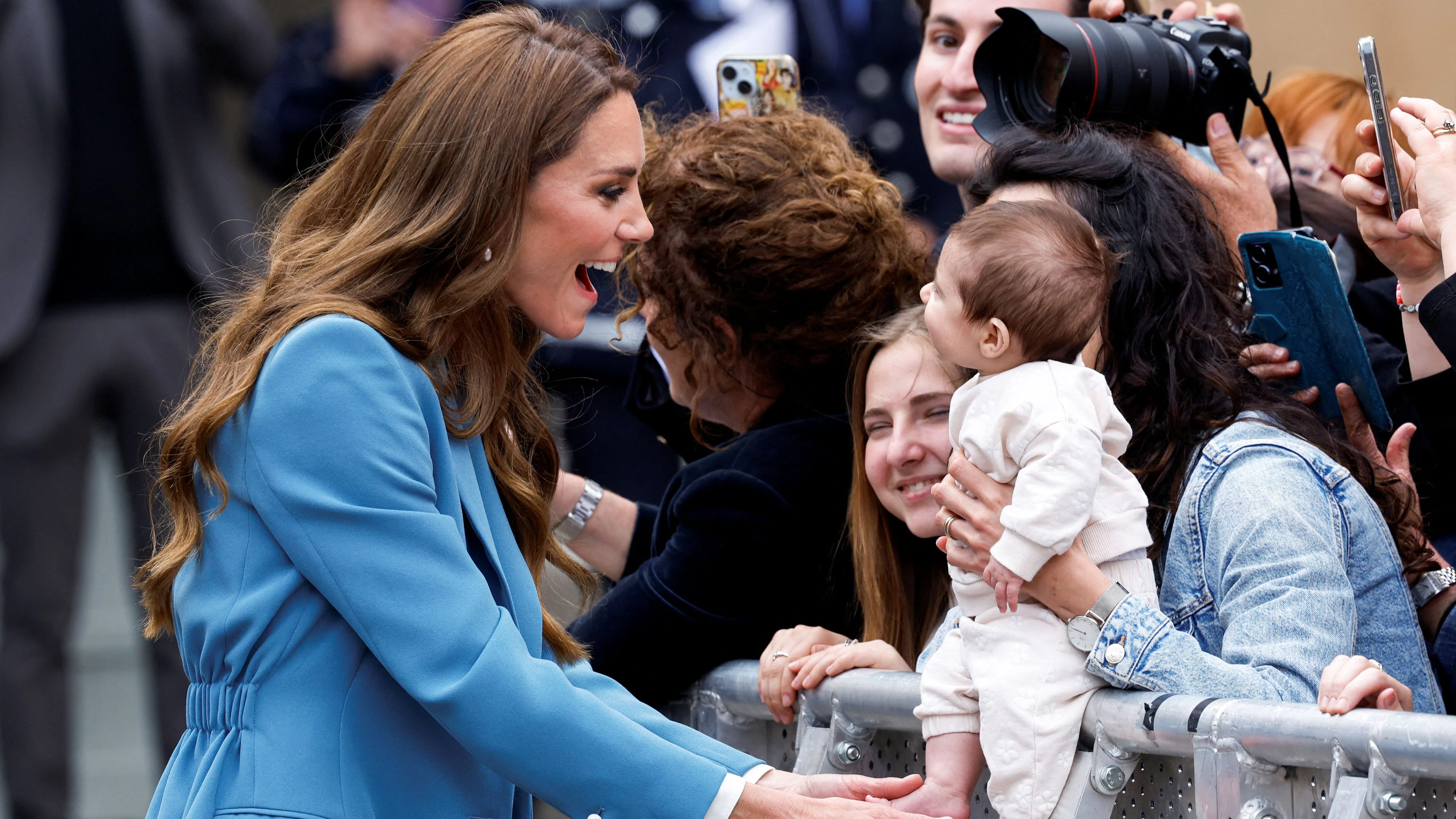 Britain's Catherine, Princess of Wales, interacts with a baby after visiting Reggio Emilia town hall during a two-day visit to the region, in Reggio Emilia, Italy, May 13, 2026. REUTERS/Remo Casilli