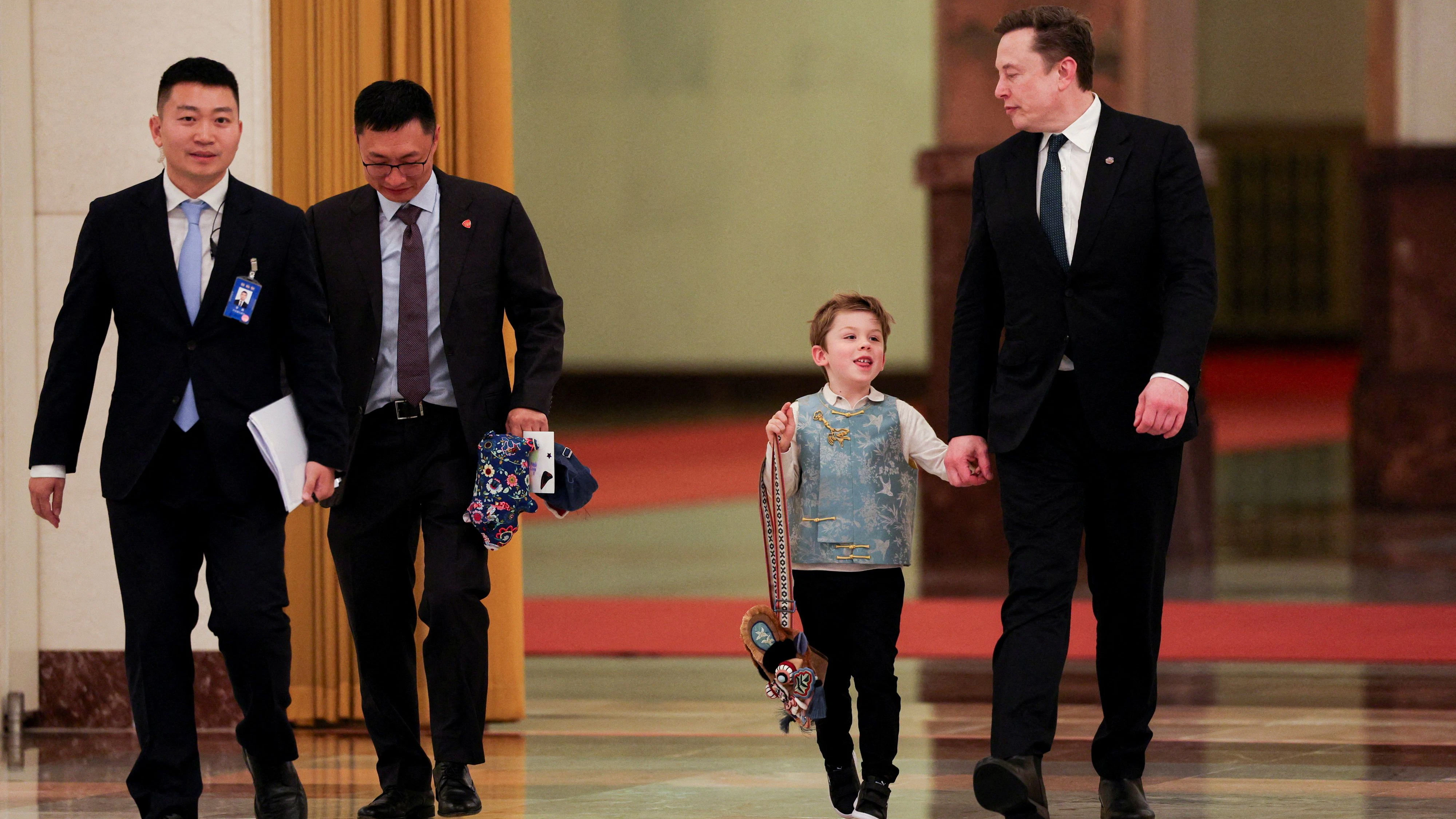 Tesla CEO Elon Musk arrives with his son X Æ A-12 for the meeting between Chinese Premier Li Qiang and U.S. business representatives, at the Great Hall of the People in Beijing, China May 14, 2026. REUTERS/Go Nakamura/Pool     TPX IMAGES OF THE DAY     