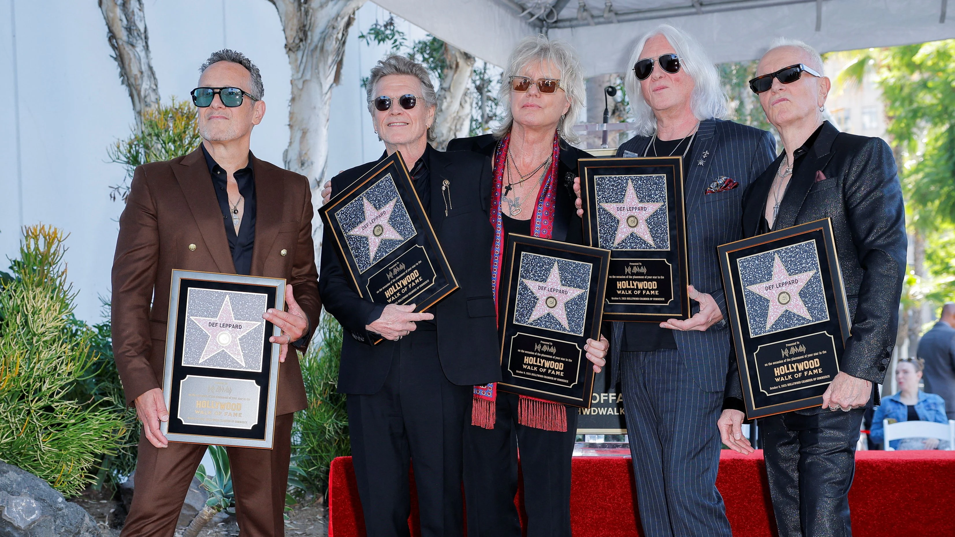 Members of Def Leppard - Joe Elliott, Rick Allen, Phil Collen, Rick Savage and Vivian Campbell, pose next to the star during unveiling ceremony for  Def Leppard, on the Hollywood Walk of Fame, in Los Angeles, California, U.S., October 9, 2025. REUTERS/Mike Blake 