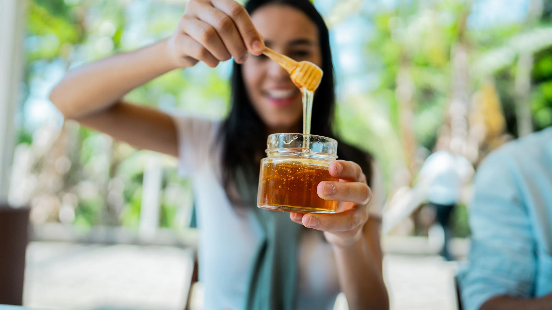 Close-up of woman holding a honey jar