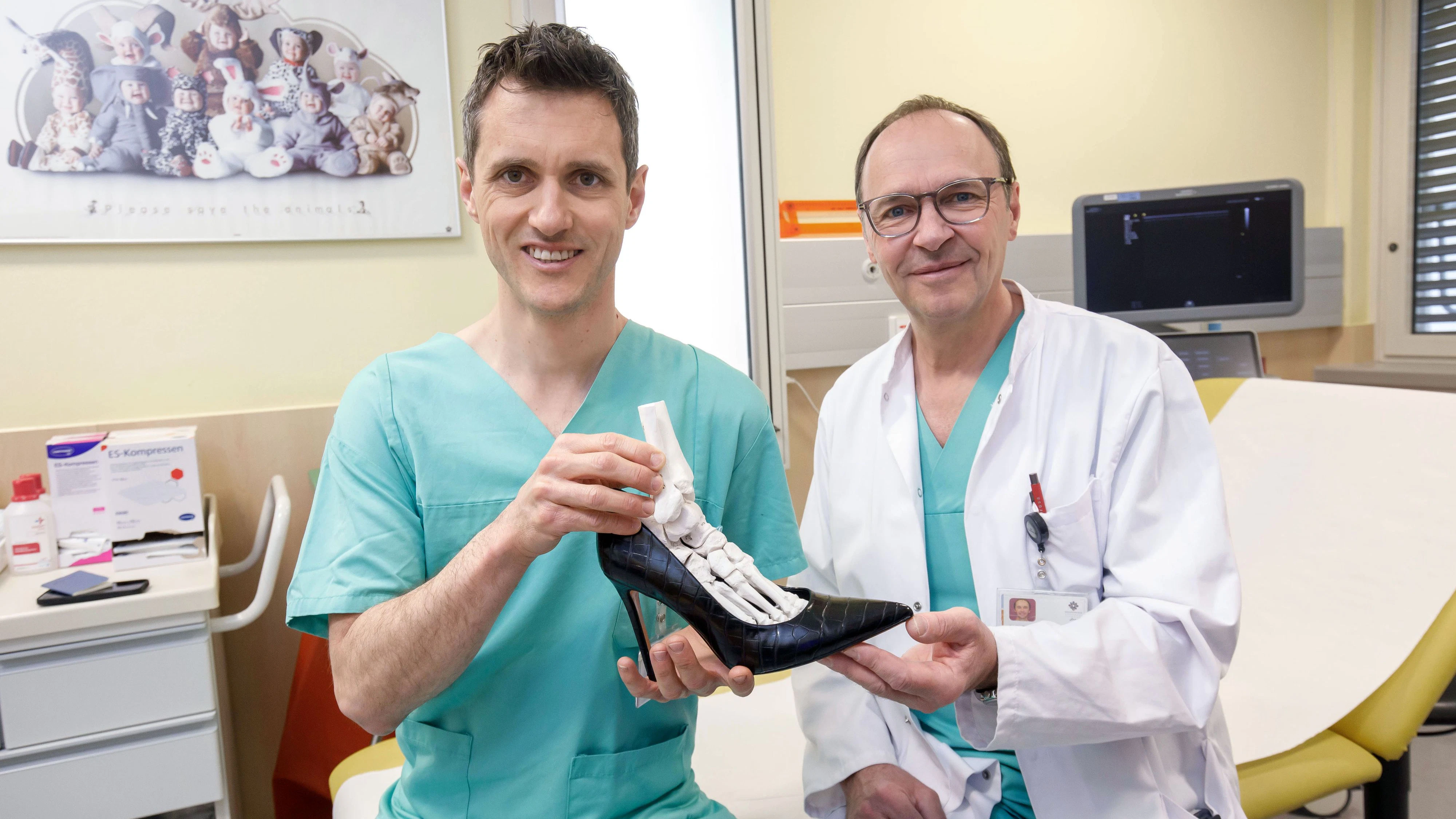 Dr. Thomas Stumpner (links) und Dr. Dietmar Mattausch zeigen die unnatürliche Stellung des Fußes in einem Schuh mit sehr hohem Absatz.