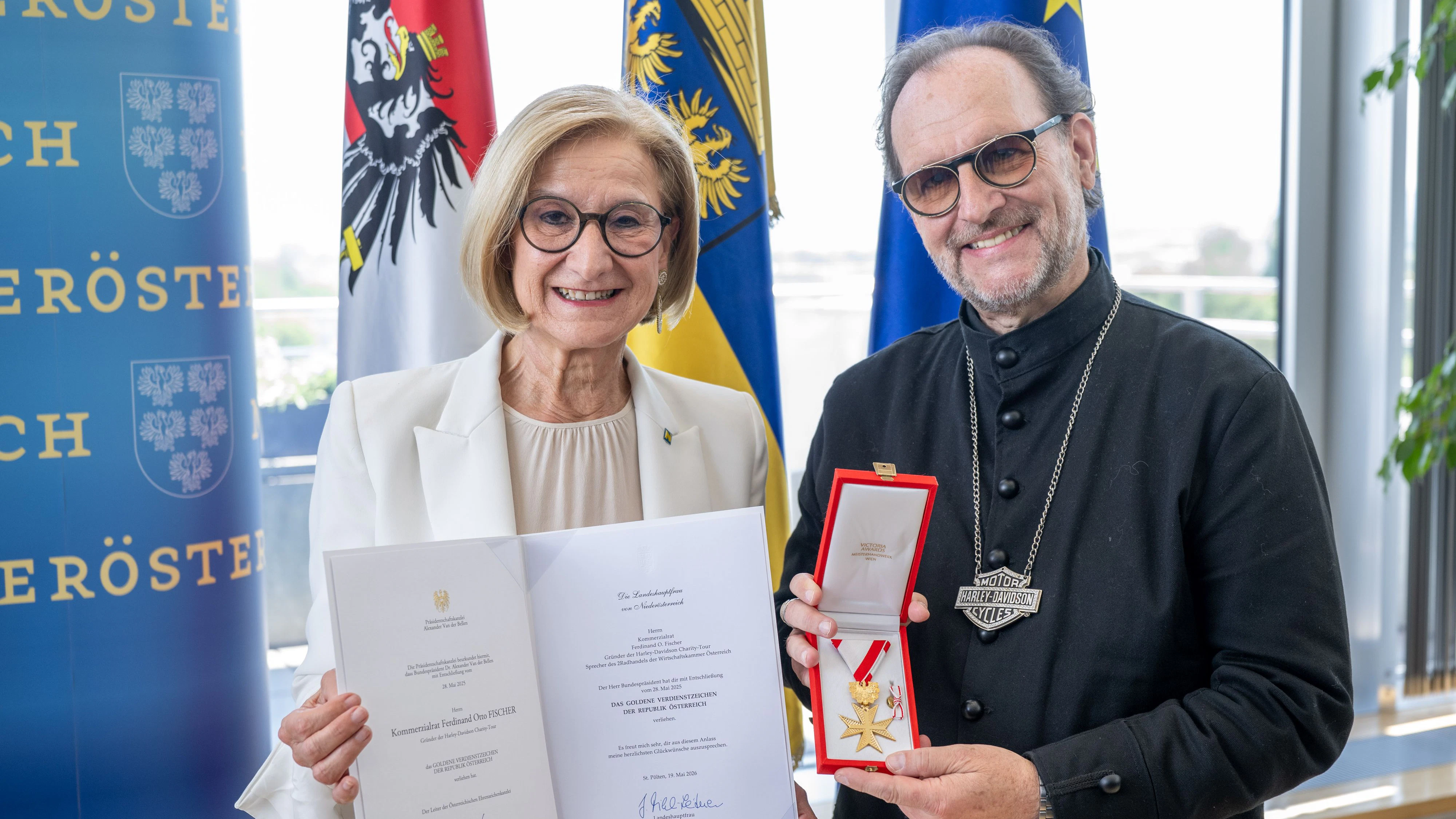Landeshauptfrau Johanna Mikl-Leitner (ÖVP, li.) überreicht Ferdinand O. Fischer (re.) das Goldene Verdienstzeichen der Republik Österreich.