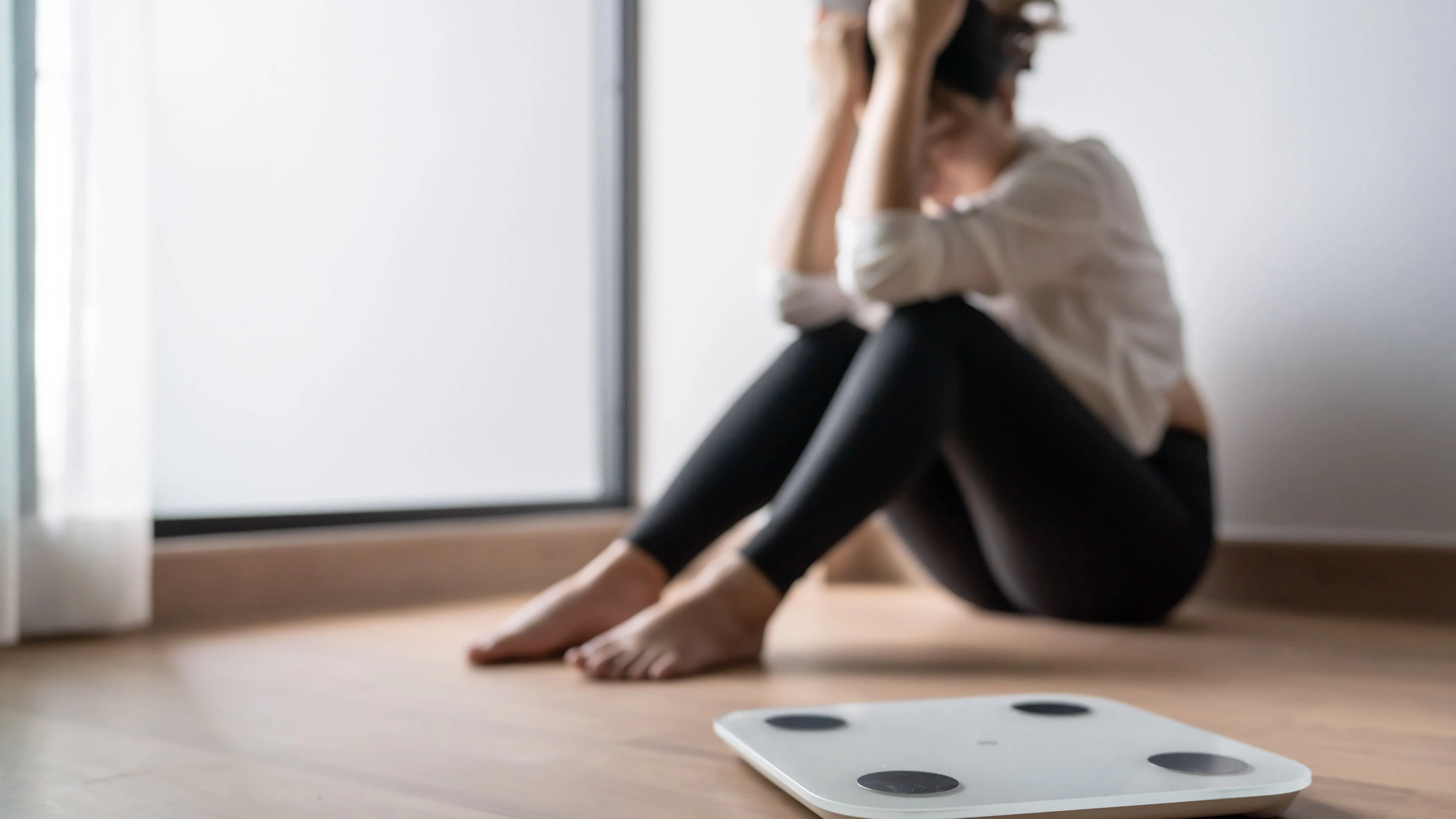 Sad woman with fat upset bored of dieting Weight loss failÂ  Fat diet and scale sad asian woman on weight scale at home weight control.