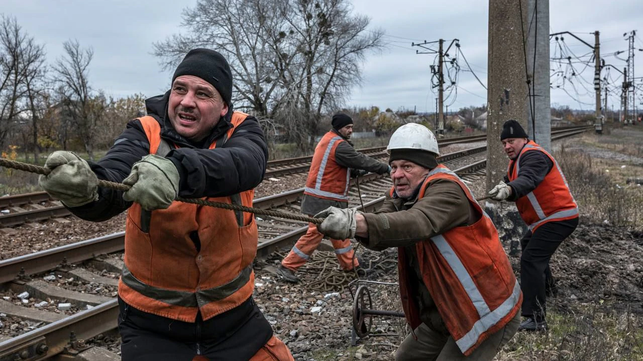 Ukrainische Eisenbahnarbeiter bringen neue Oberleitungen an und stellen damit einen durch russische Bombardements zerstörten Abschnitt der Eisenbahnstrecke wieder her. 
