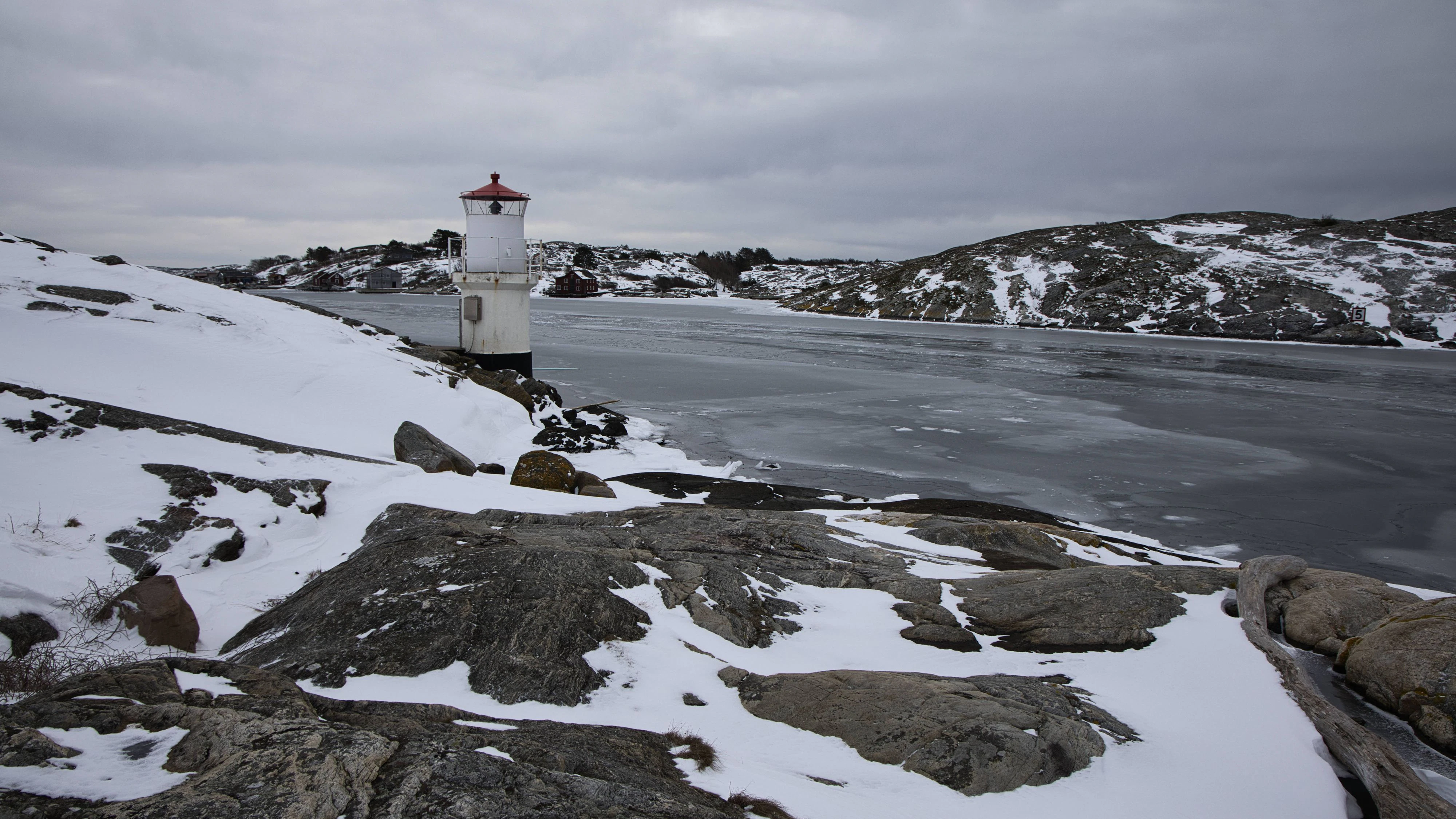 Kleiner weißer Leuchtturm mit rotem Dach an der zugefrorenen Küste von Møllsund, Schweden. Winterlandschaft aus Eis und Schnee. Kleiner weißer Leuchtturm mit rotem Dach an der zugefrorenen Küste von Møllsund, Schweden. Nordische Seezeichen in einer winterlichen Landschaft aus Eis und Schnee. LicenseRF Copyright: xZoonar.com/JanxWehnertx 24773538