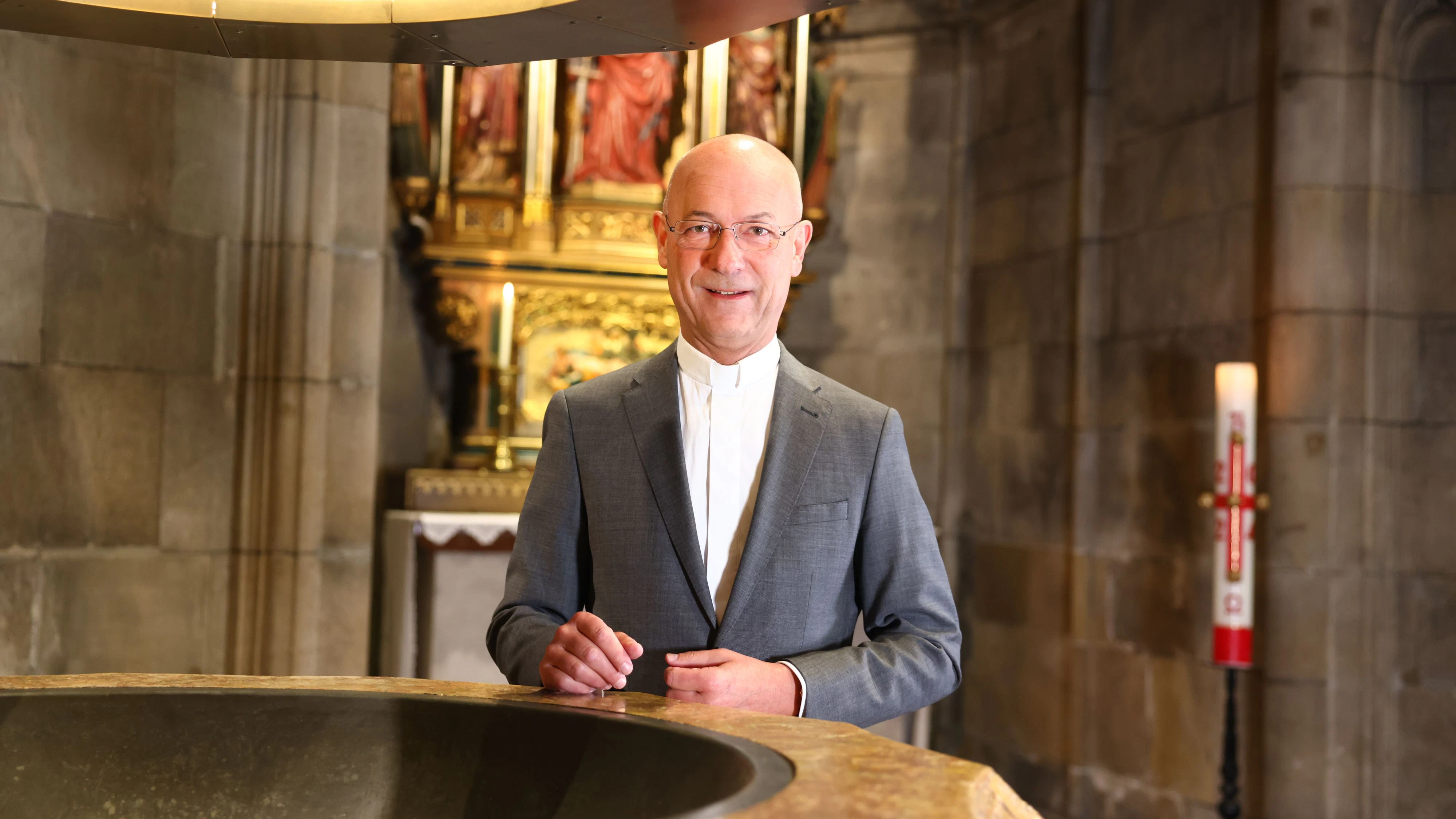 Dompfarrer Toni Faber am Taufbecken im Wiener Stephansdom. 