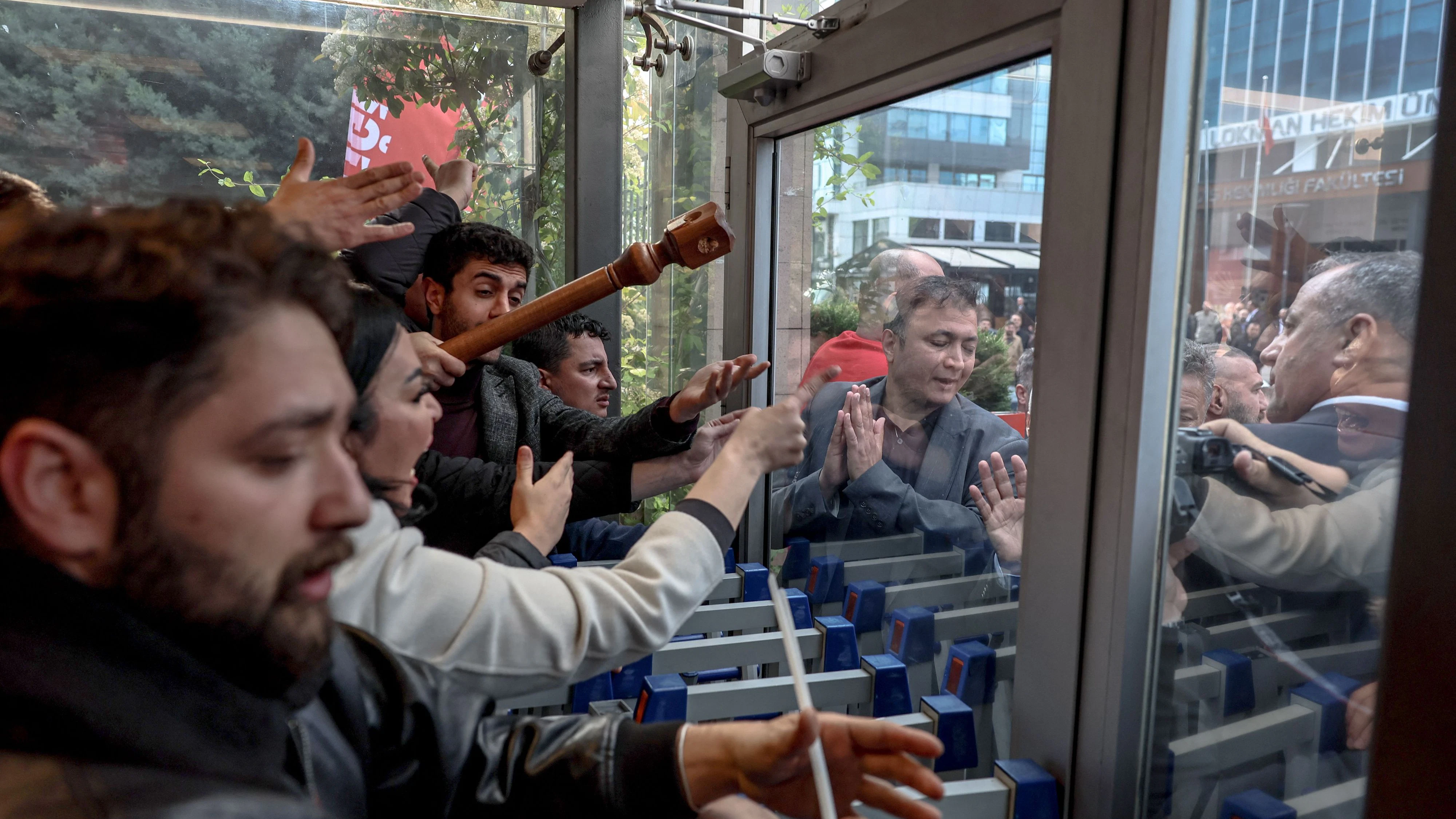 Supporters of the Republican People's Party (CHP) leader Ozgur Ozel and supporters of former party leader Kemal Kilicdaroglu clash outside the party headquarters in Ankara, on May 24, 2026. Thousands rallied on May 22 in Ankara and Istanbul to protest against a court verdict ousting the popular leader of Turkey's main opposition CHP party in the latest government crackdown on foes. An Ankara court on May 21 annulled a 2023 leadership election for the Republican People's Party (CHP), citing alleged vote buying. (Photo by Adem ALTAN / AFP)