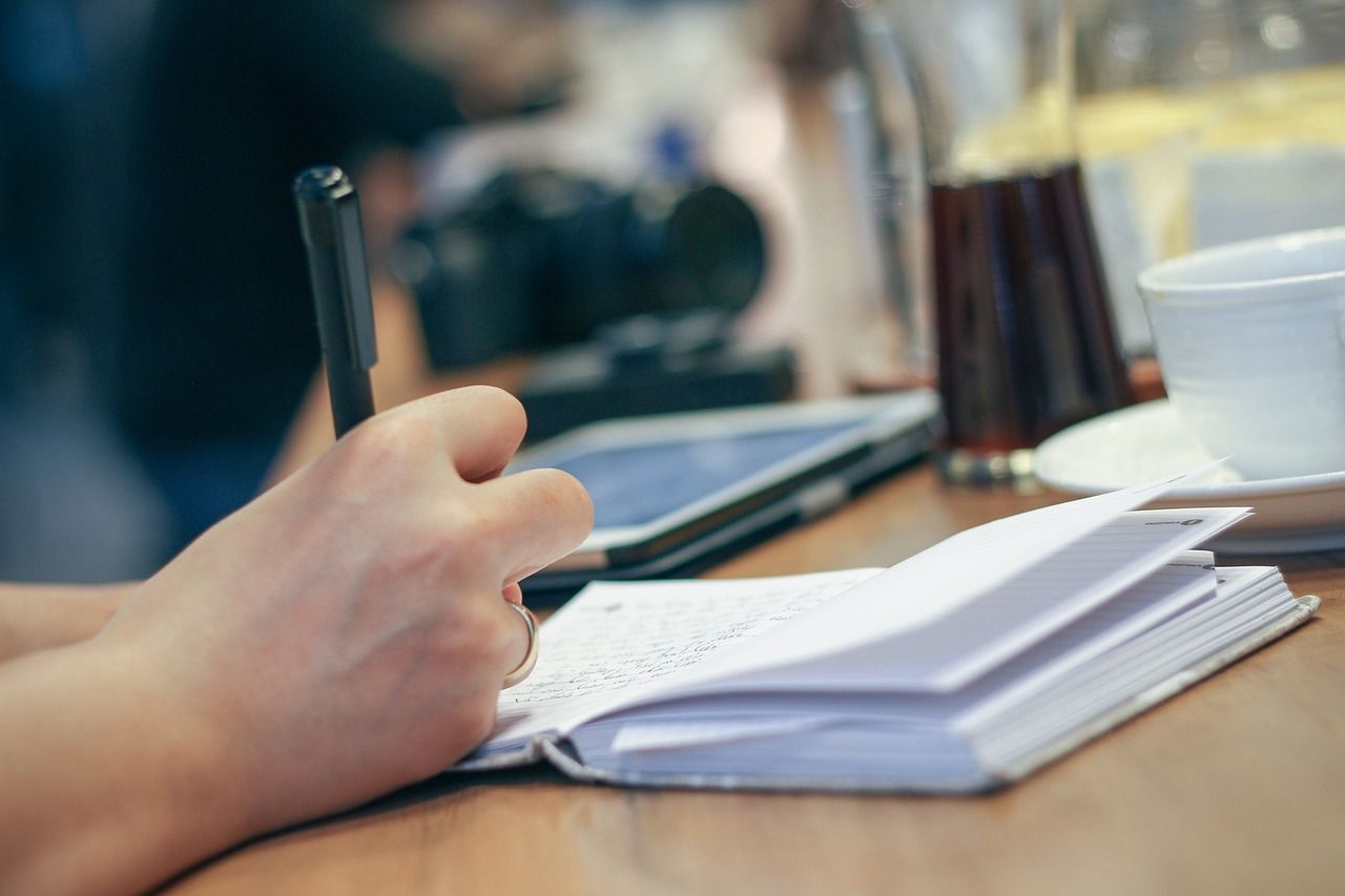 Hand schreibt in ein Notizbuch