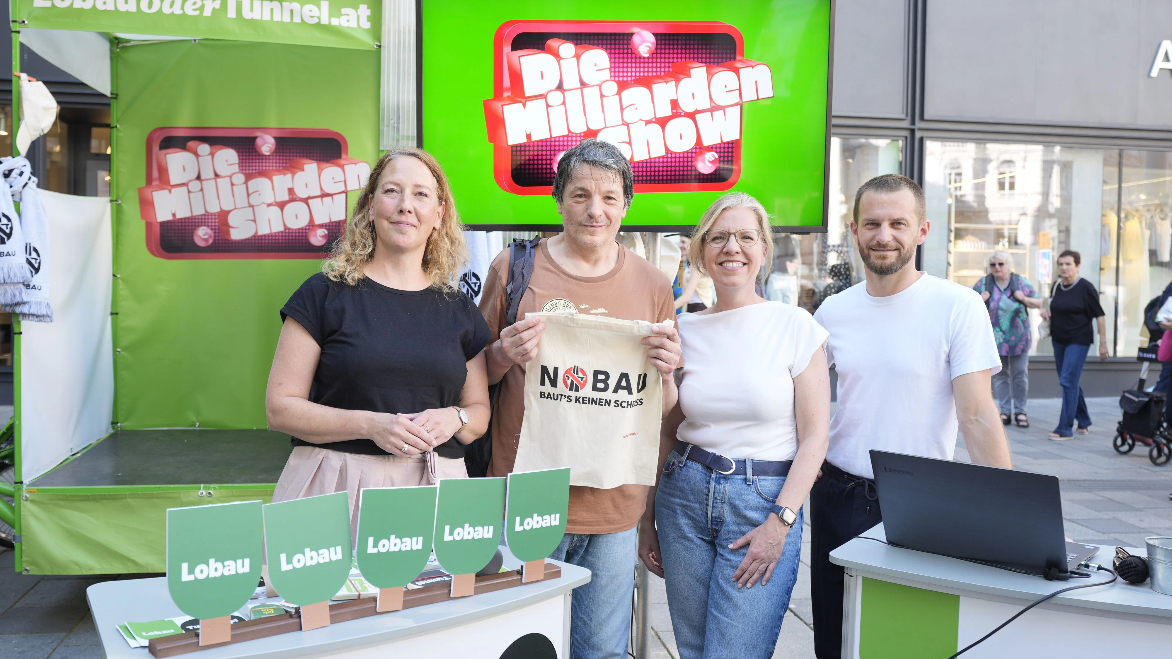 Grünen-Bundesvorsitzende Leonore Gewessler und die Wiener Grünen-Chefs Judith Pühringer und Peter Kraus moderierten am Dienstag auf der Mariahilfer Straße die Lobau-"Milliardenshow". In Anlehnung an die TV-Sendung "Millionenshow" können Passanten dabei Fragen beantworten wie: "Wofür könnten sechs Milliarden Euro sinnvoller eingesetzt werden?“ Oder „Was bedeutet der Name ’Lobau’ ursprünglich?" Zu gewinnen gibt es unter anderem Merchandise aus der "Nobau"-Kollektion.
