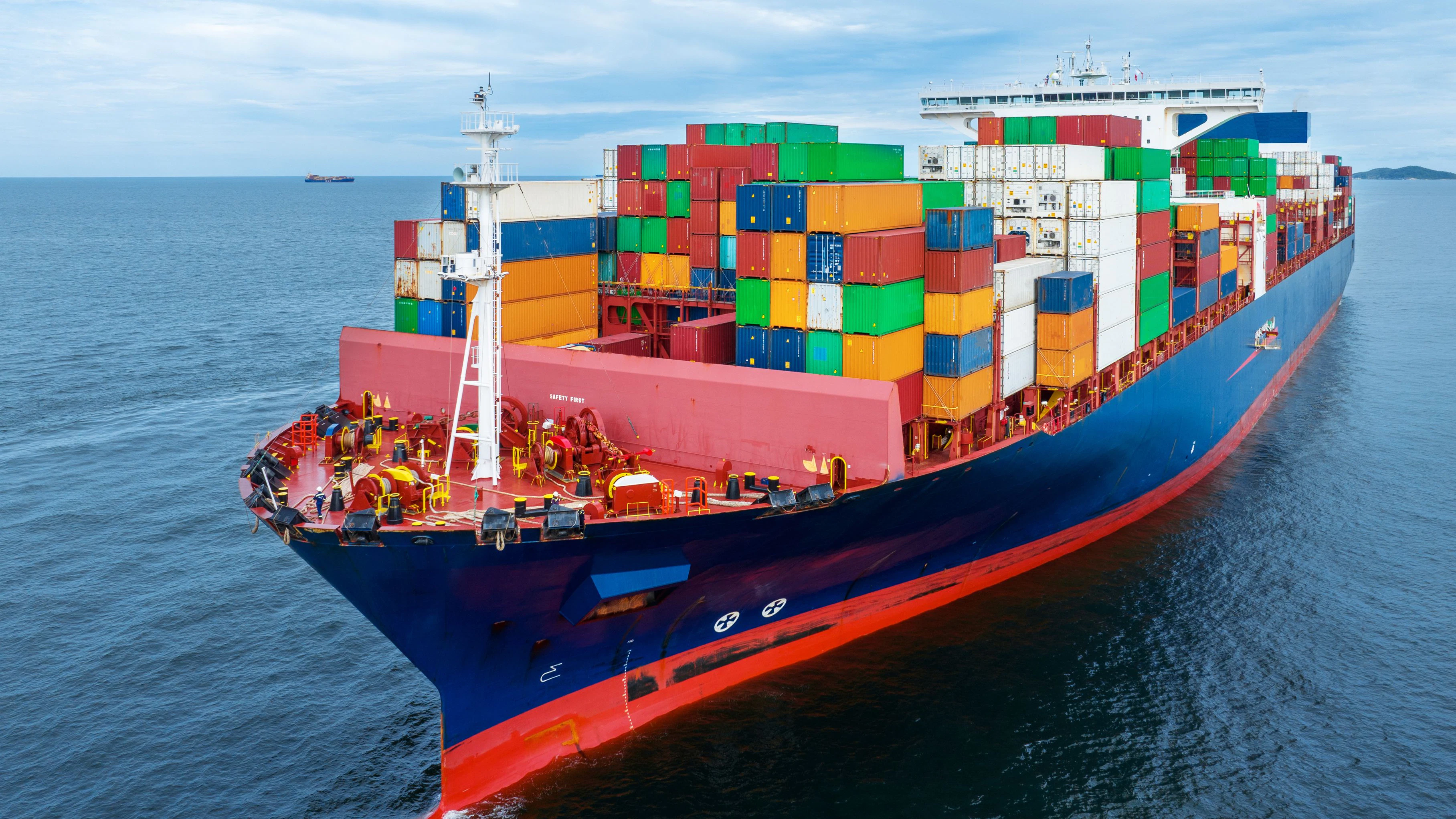 Aerial side view of  cargo container ship carrying container from custom container depot go to ocean concept freight shipping by ship service on blue sky .Freight Forwarding Service