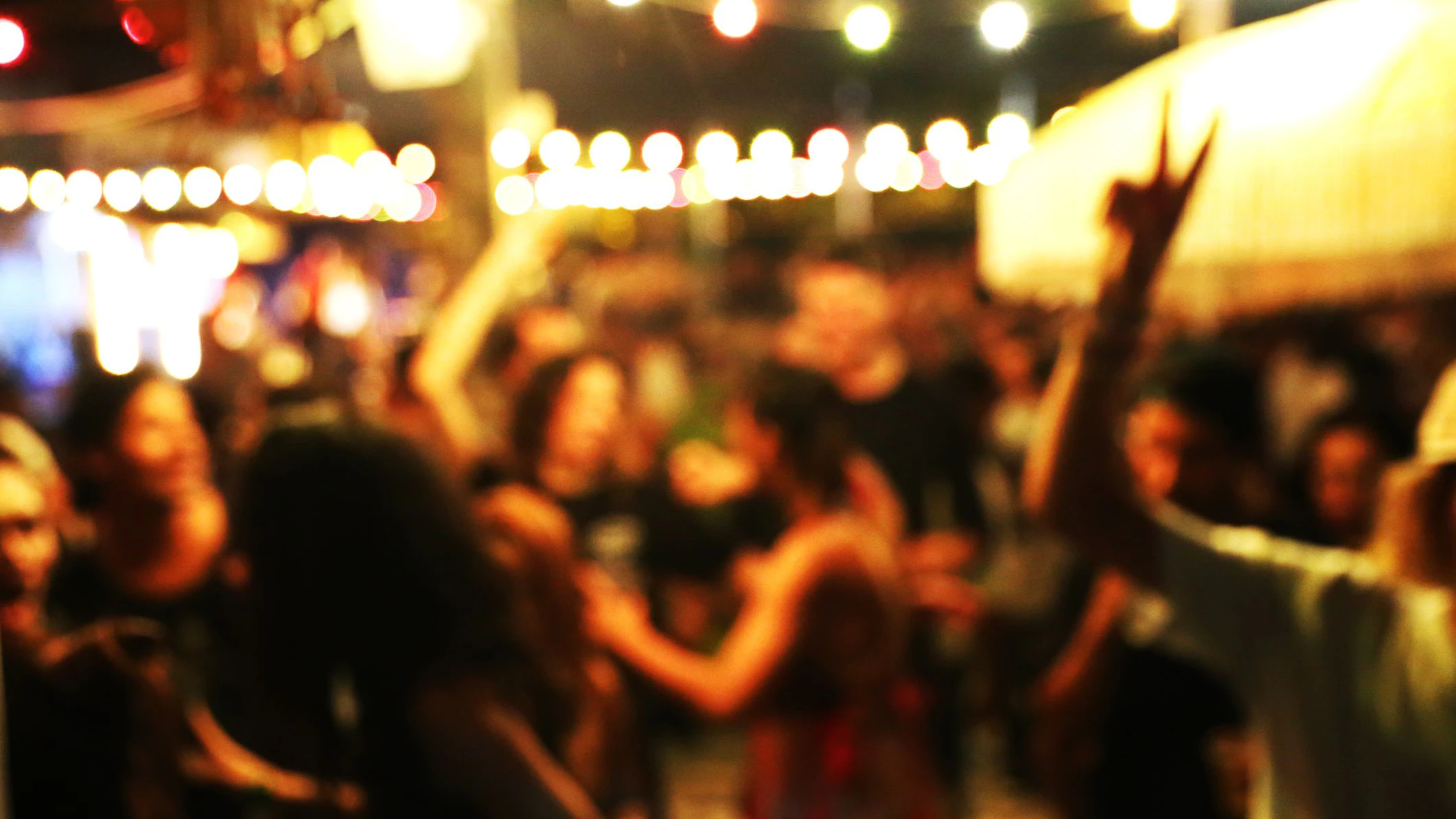 Blurred background of many people had fun at a beach party. Festive concept.