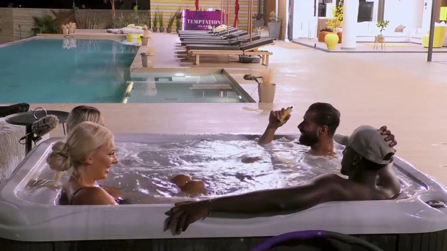 Momo fummelt im Whirlpool mit den Füßen an den Verführerinnen herum. 