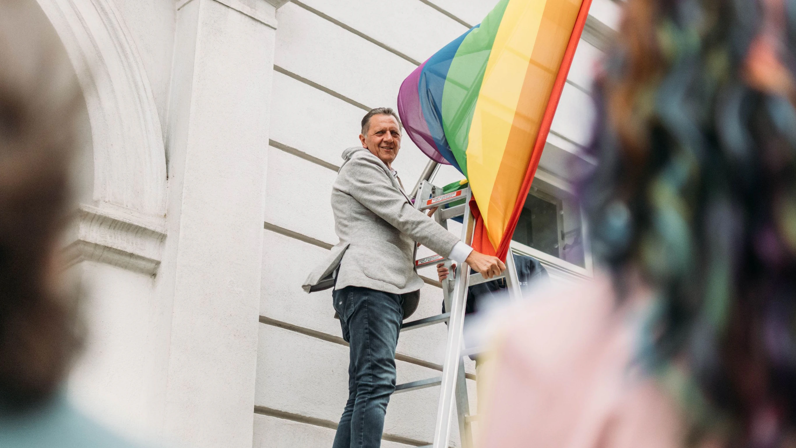 Thomas Steinhart, Bezirksvorsteher von Simmering, beim Hissen der Regenbogenfahne vor dem Amthaus