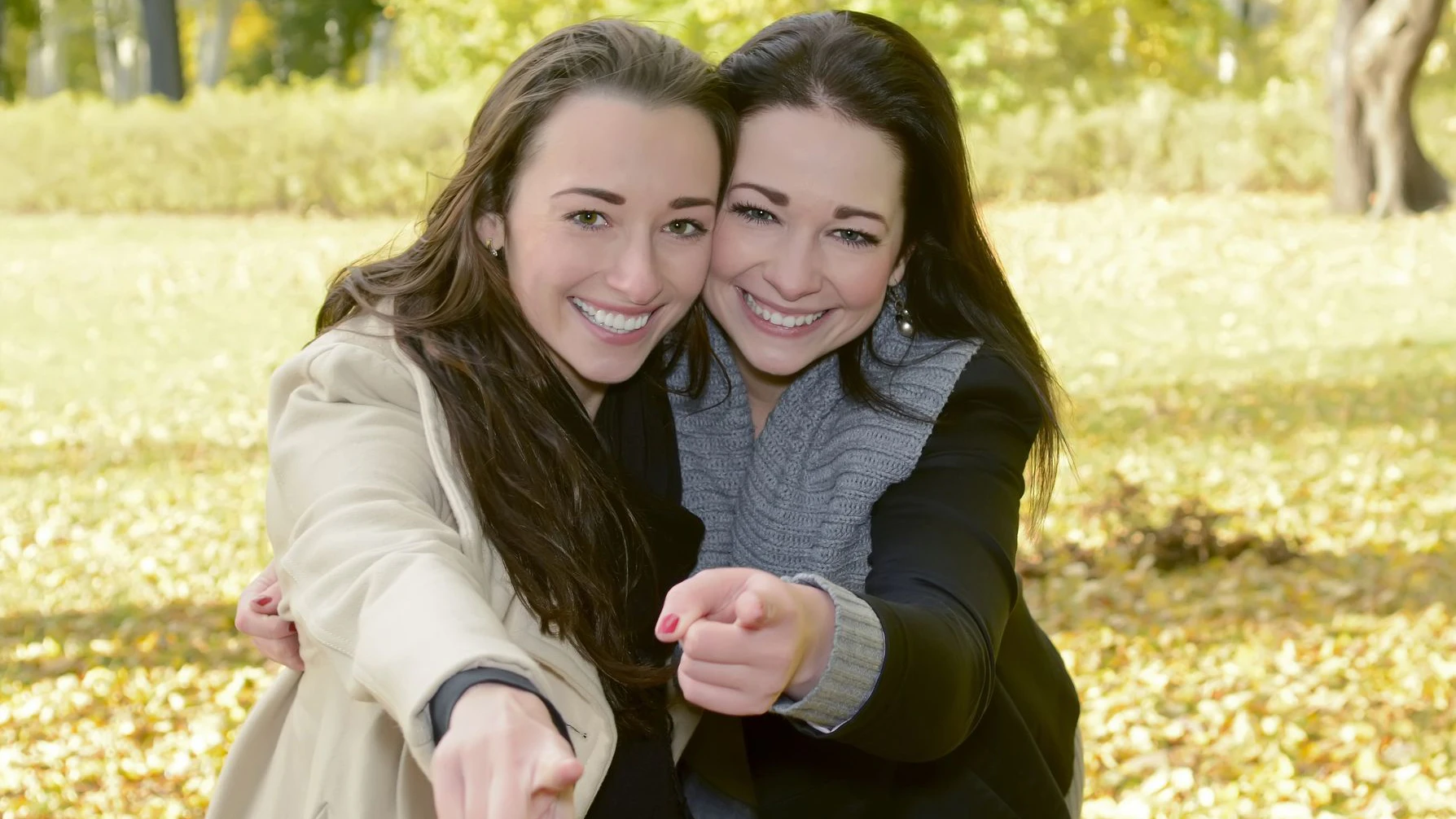 lively sisters in autumn park