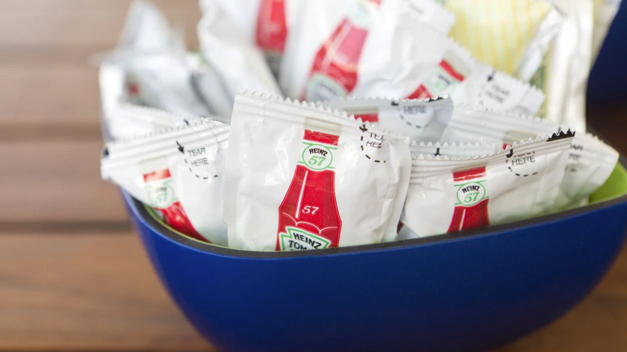 "Nassau, Bahamas - March 28, 2012: Bowl containing condiment packets of Heinz 57 ketchup on restaurant table."