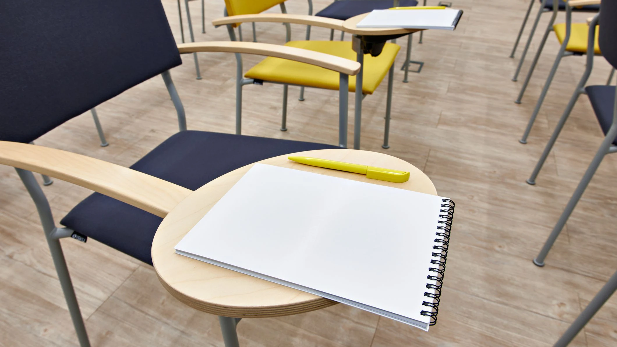 Chairs with notepads in an empty classroom