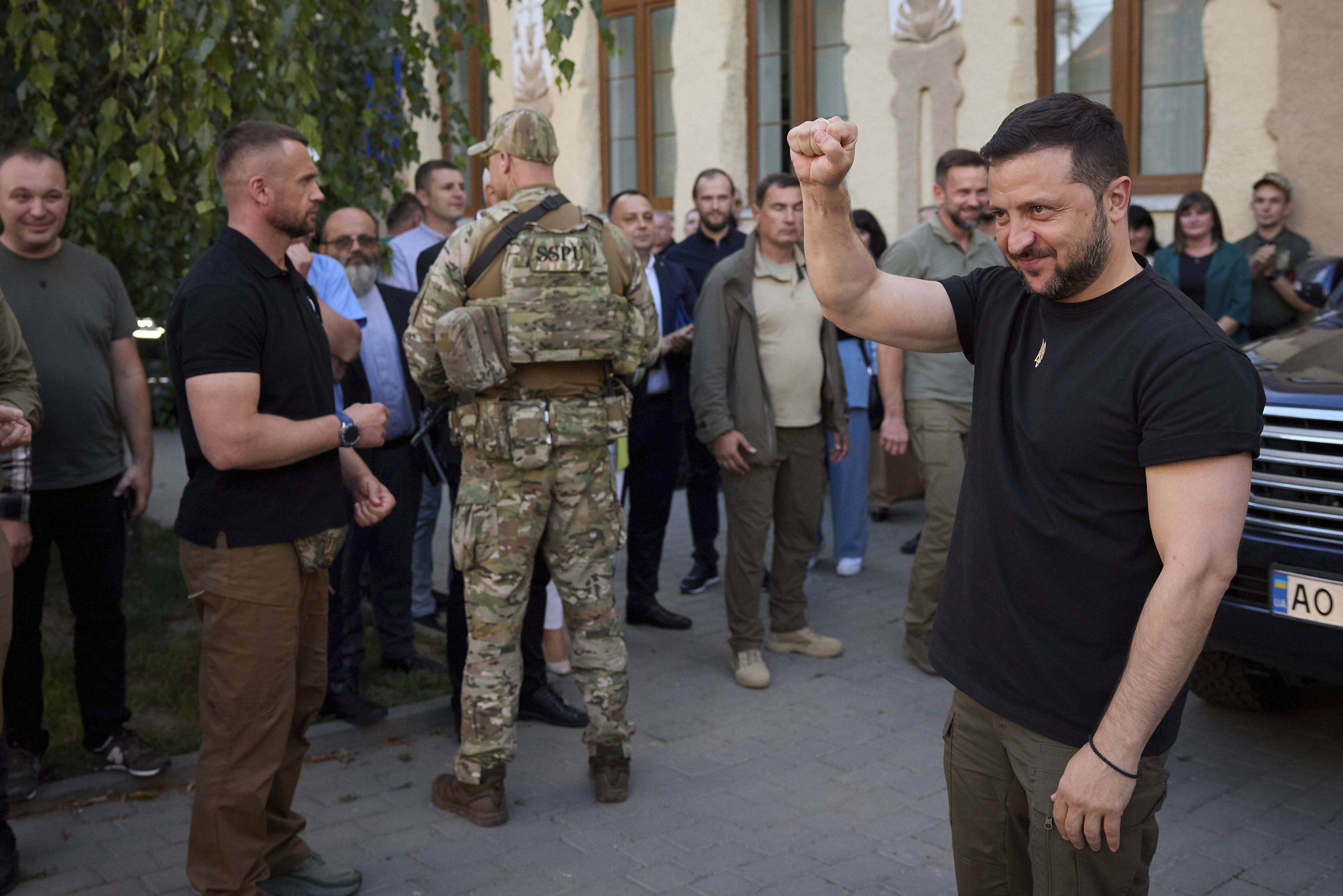 Der ukrainische Präsident Wolodymyr Selenskyj (rechts) winkt einer jubelnden Menge nach einem Treffen mit Mitgliedern der ungarischen Gemeinde in der Region Transkarpatien am 2. August 2023 in Berehove.
