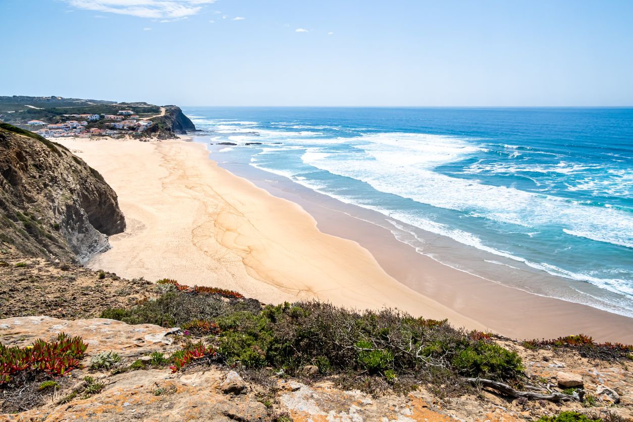 Praia do Monte Clérigo begeistert mit goldenen Klippen, weitem Sandstrand und spektakulären Sonnenuntergängen.