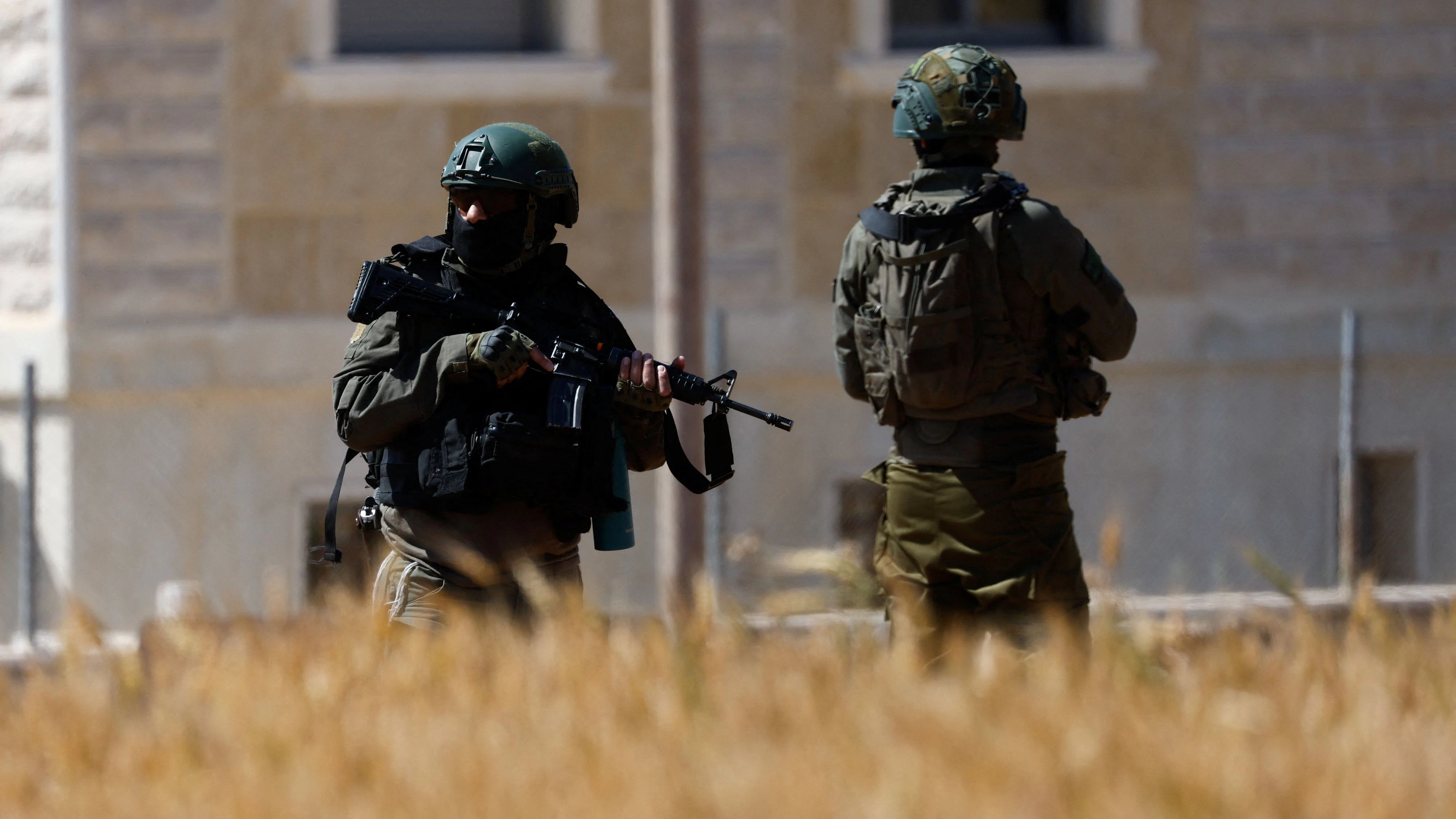 Israeli troops stand guard as heavy machinery demolishes a Palestinian building near Hebron, in the Israeli-occupied West Bank, May 4, 2026. REUTERS/Mussa Qawasma