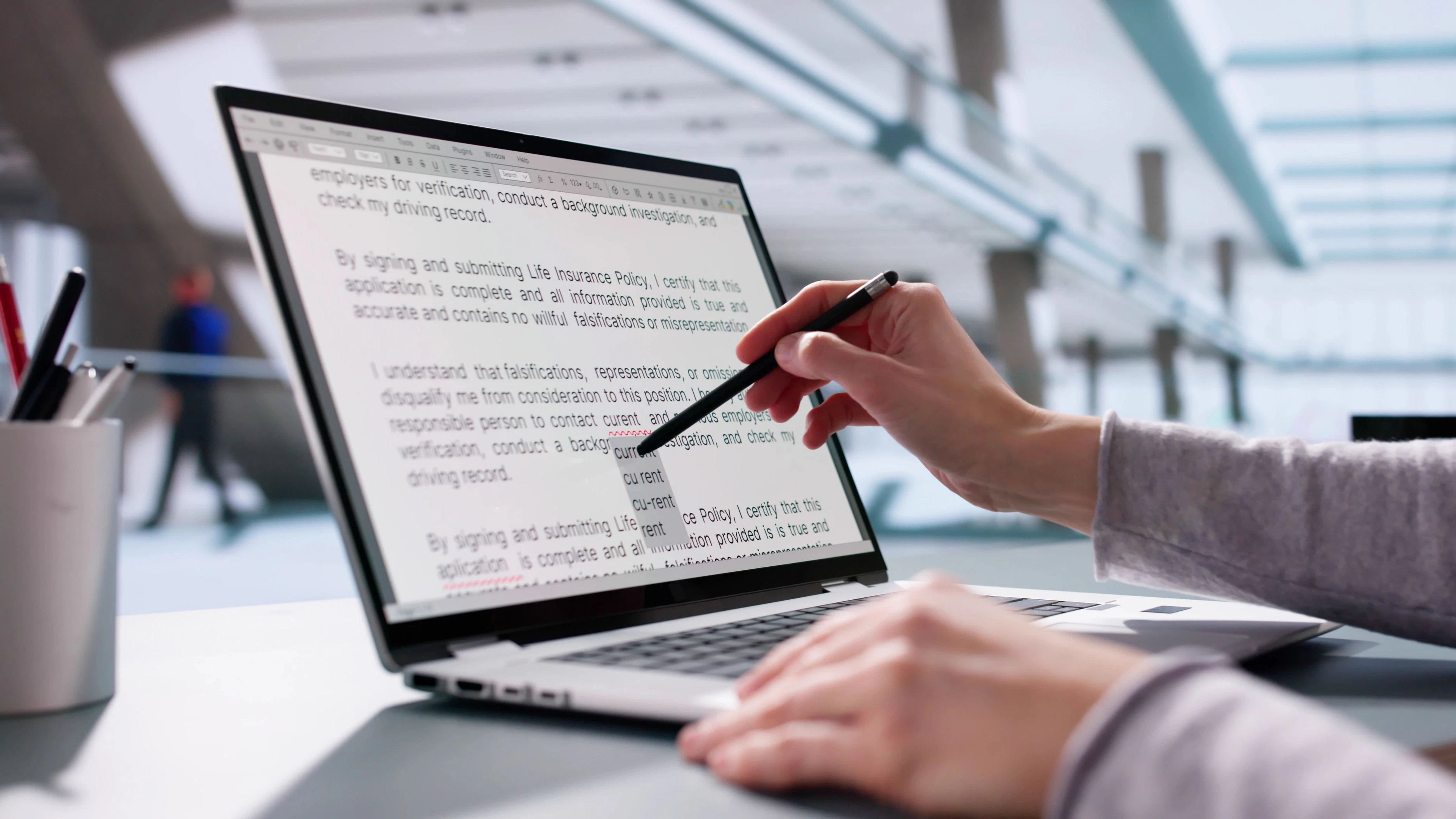 Young woman proofreads script on laptop, corrects errors, edits content.