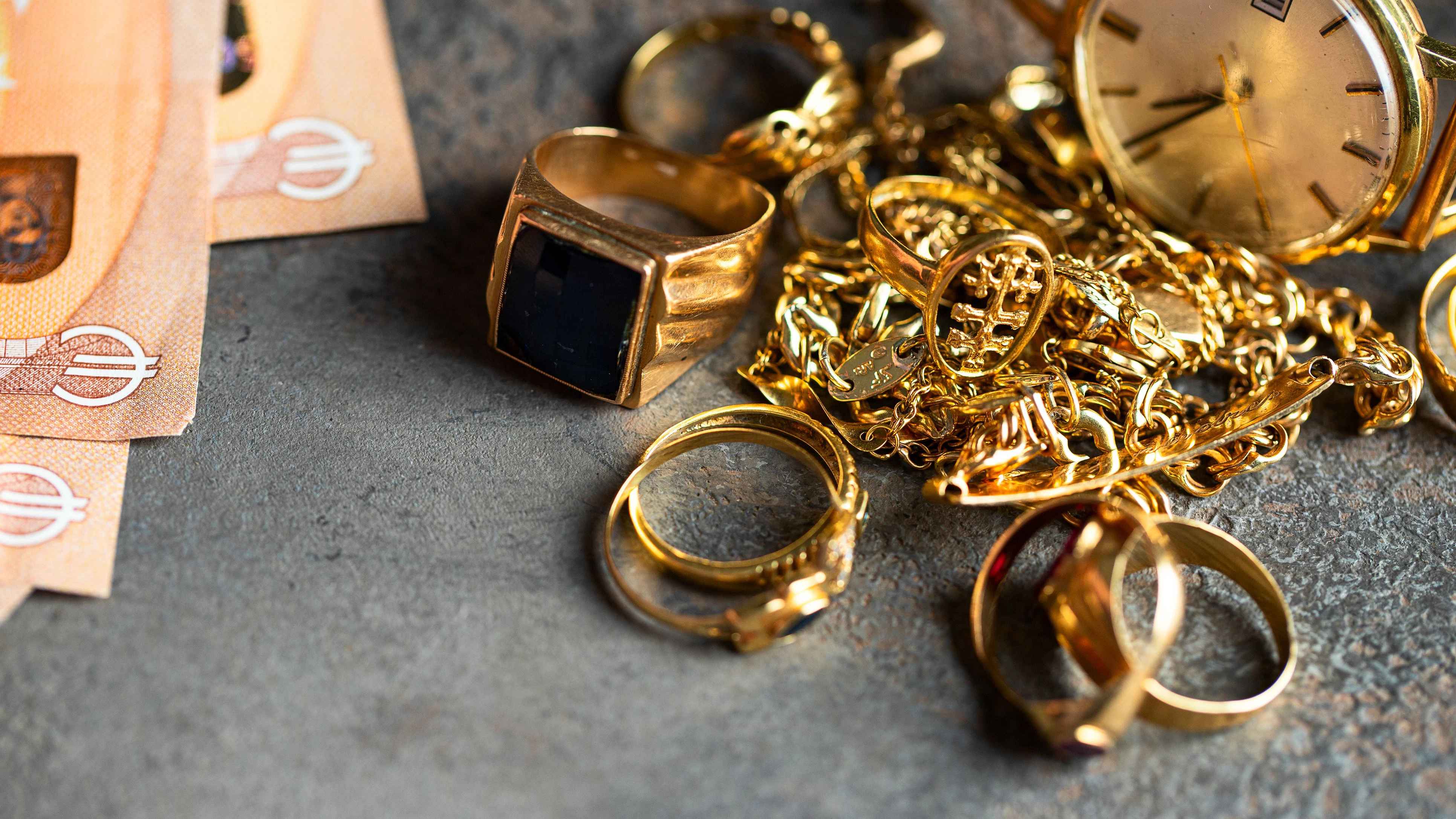 Old and broken jewelry  and on Euro banknotes on dark background. Sell gold for money  concept.