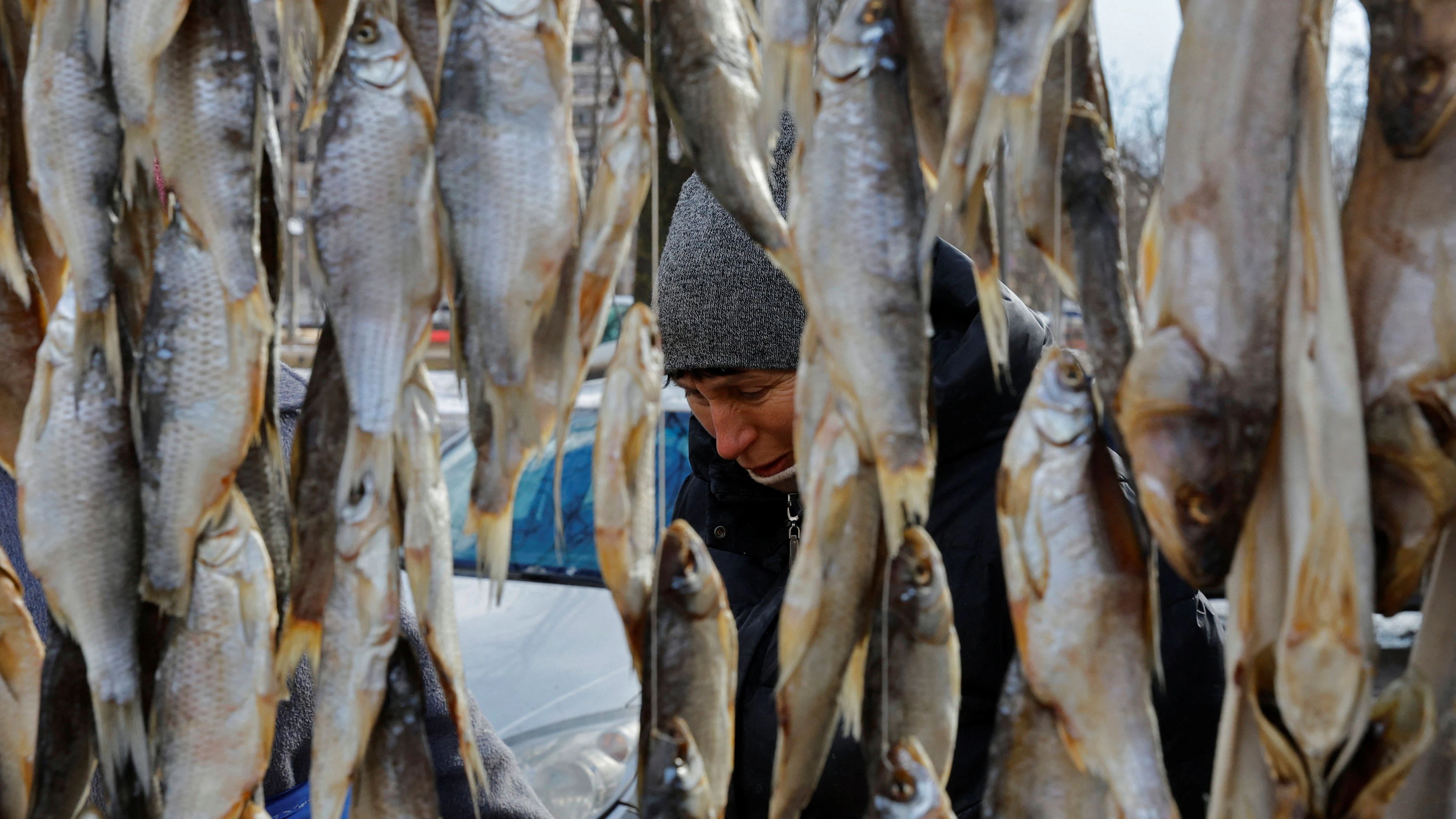 A vendor sells dried fish at a local market in the course of Russia-Ukraine conflict in Mariupol, Russian-controlled Ukraine, February 16, 2023. REUTERS/Alexander Ermochenko