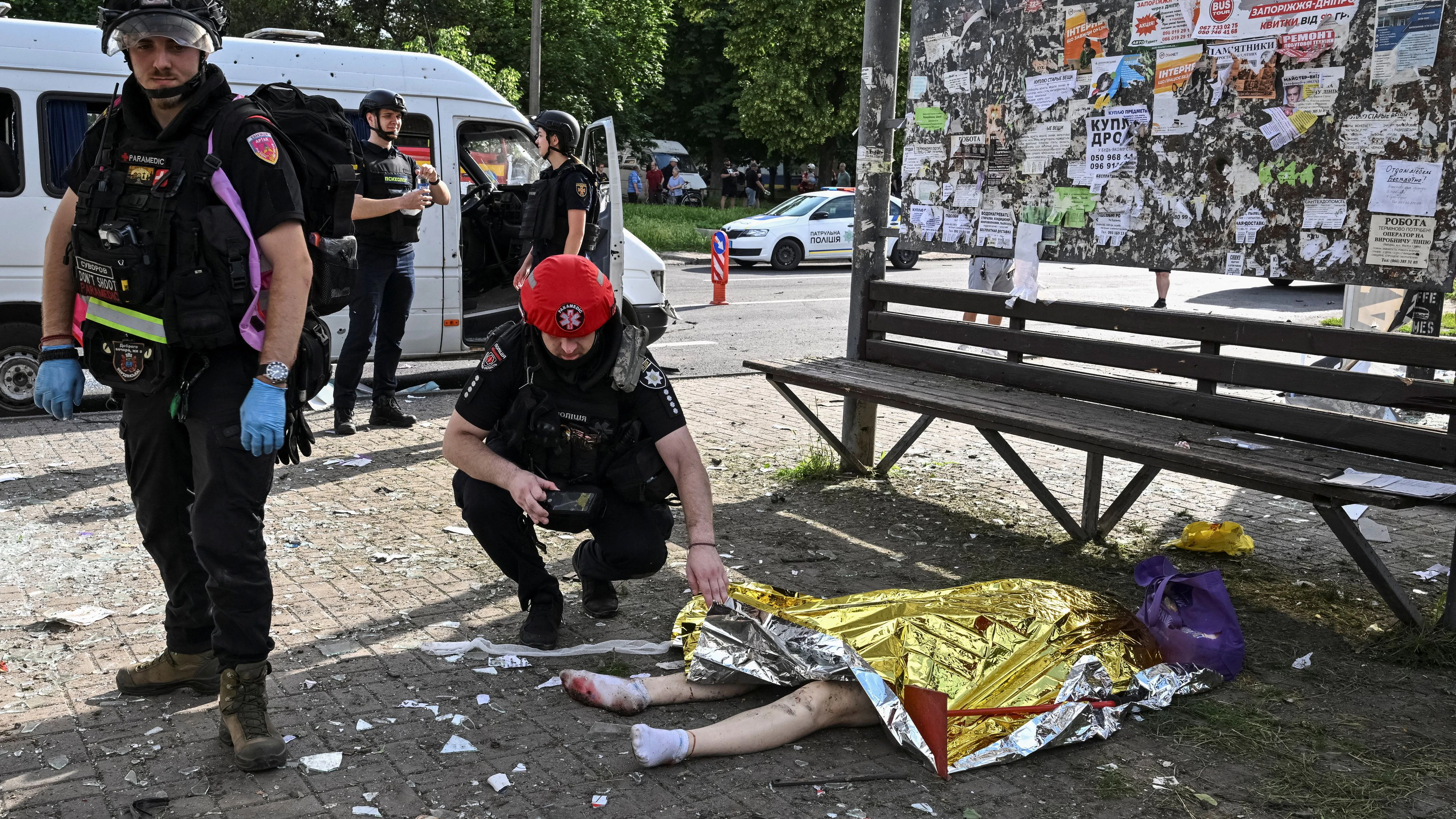 SENSITIVE MATERIAL. THIS IMAGE MAY OFFEND OR DISTURB  A medical worker and a police officer near a body of a killed resident at a bus stop at the site of a Russian drone strike, amid Russia's attack on Ukraine, in Zaporizhzhia, Ukraine June 8, 2026. REUTERS/Stringer