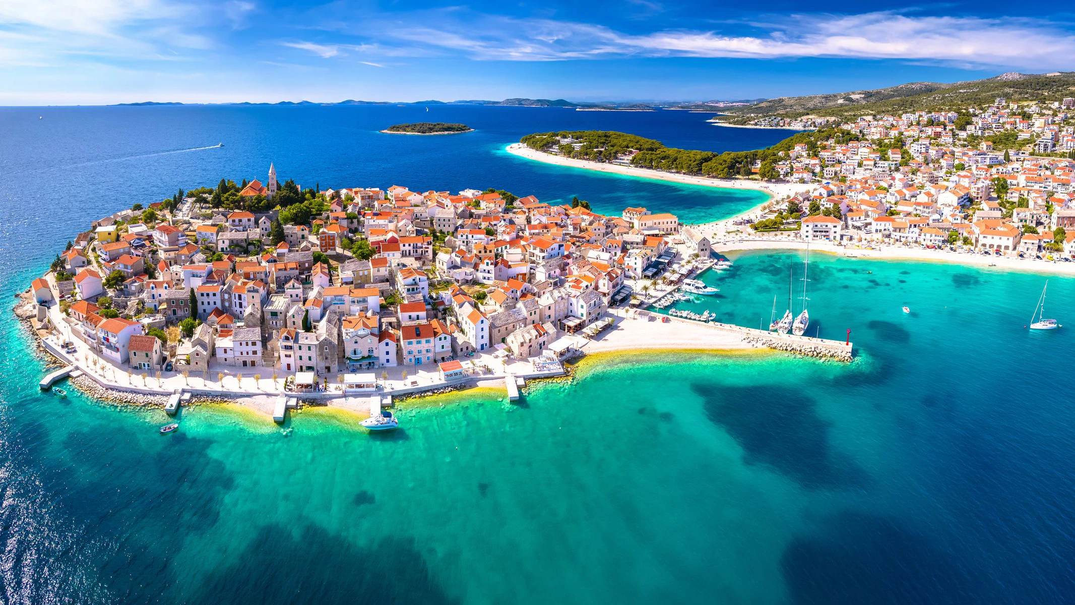 Scenic town and beaches of Primosten aerial panoramic view, turquoise archipelago and historic architecture of Croatia