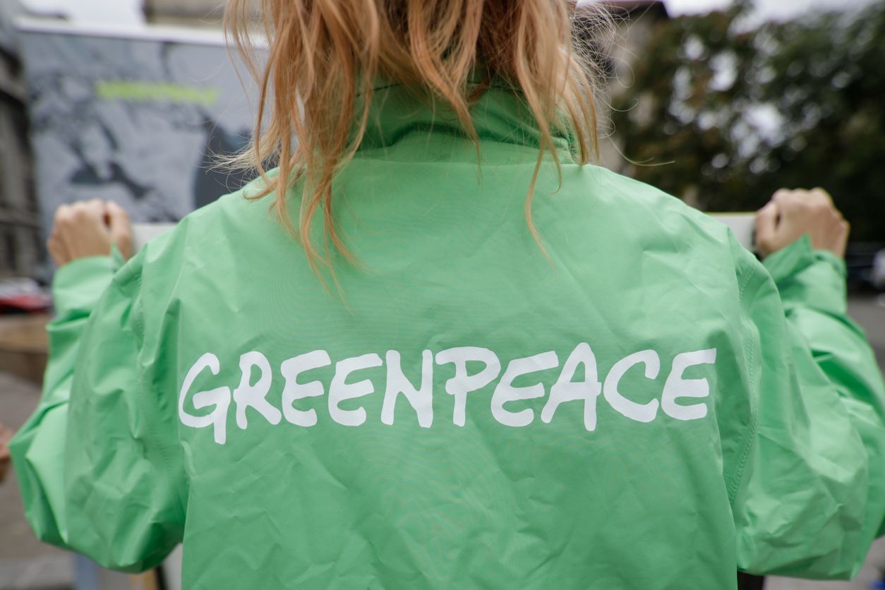 Bucharest, Romania - October 1, 2020: Greenpeace activist holding a banner at a protest.
