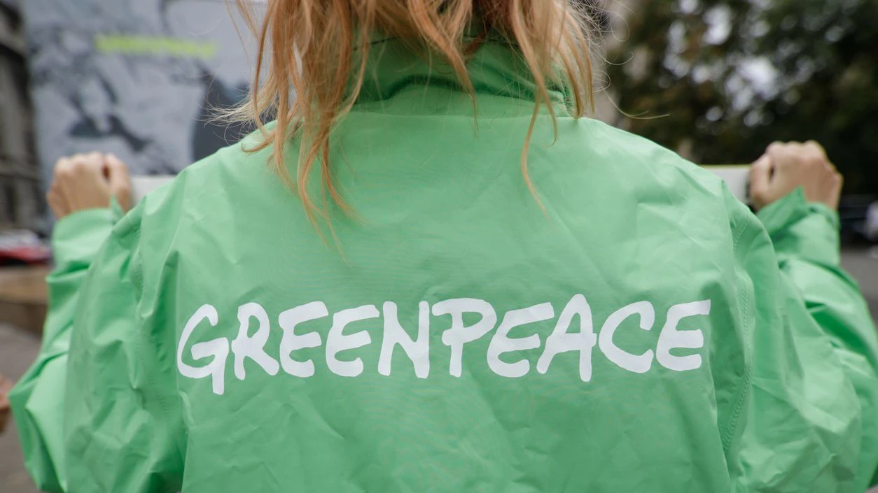 Bucharest, Romania - October 1, 2020: Greenpeace activist holding a banner at a protest.