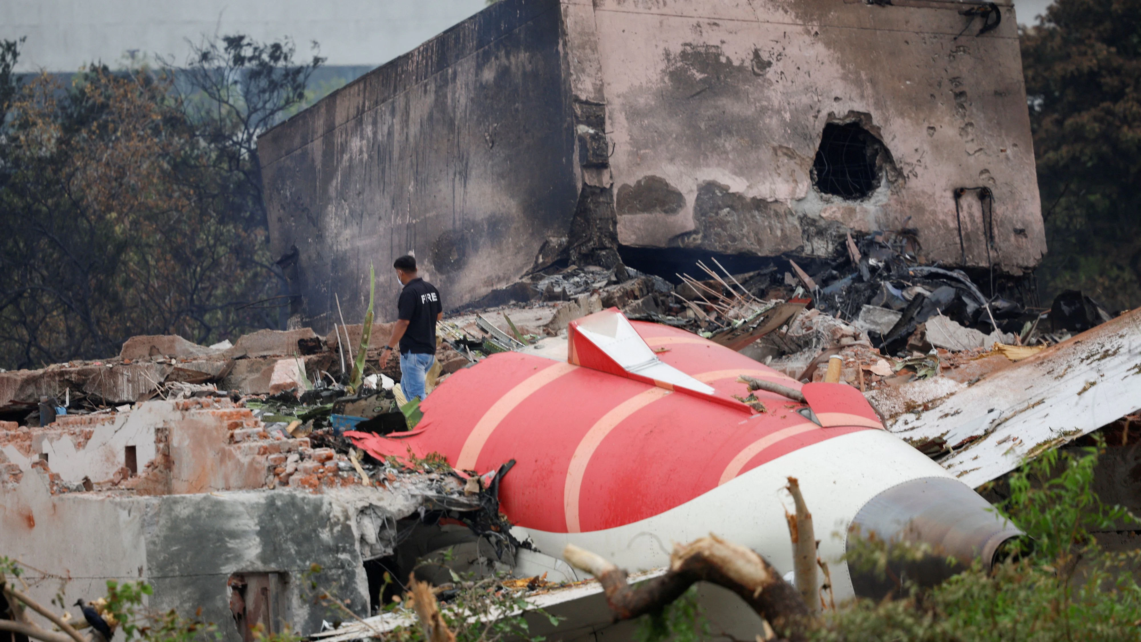 FILE PHOTO: A fire offical stands next to the crashed Air India Boeing 787-8 Dreamliner aircraft, in Ahmedabad, India, June 13, 2025. REUTERS/Adnan Abidi/File Photo