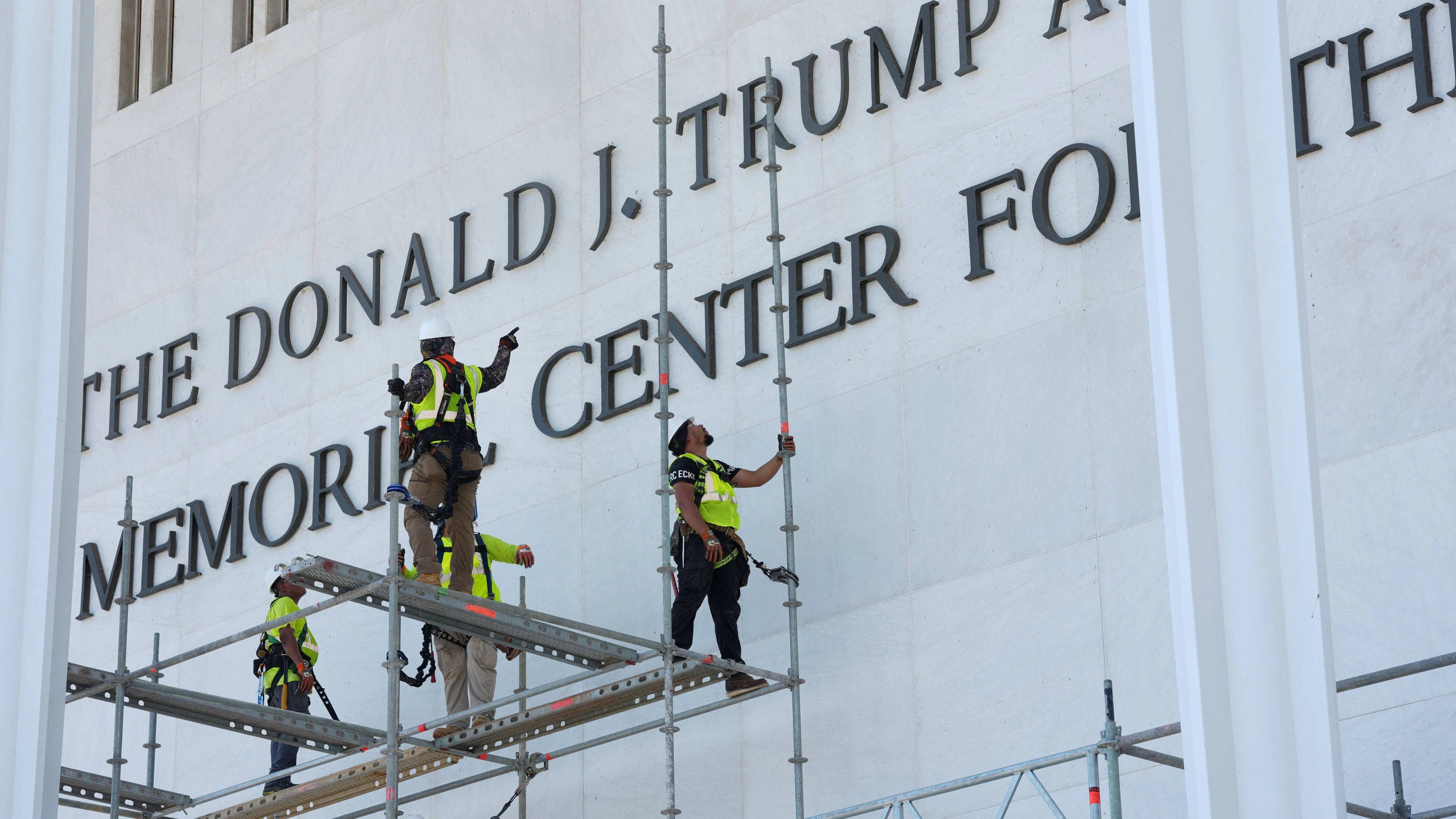 People work as they remove the lettering referencing U.S. President Donald Trump from the facade of the John F. Kennedy Center for the Performing Arts, after a federal judge ordered that President Trump's name be removed from the building in Washington, D.C., U.S., June 12, 2026. REUTERS/Ken Cedeno