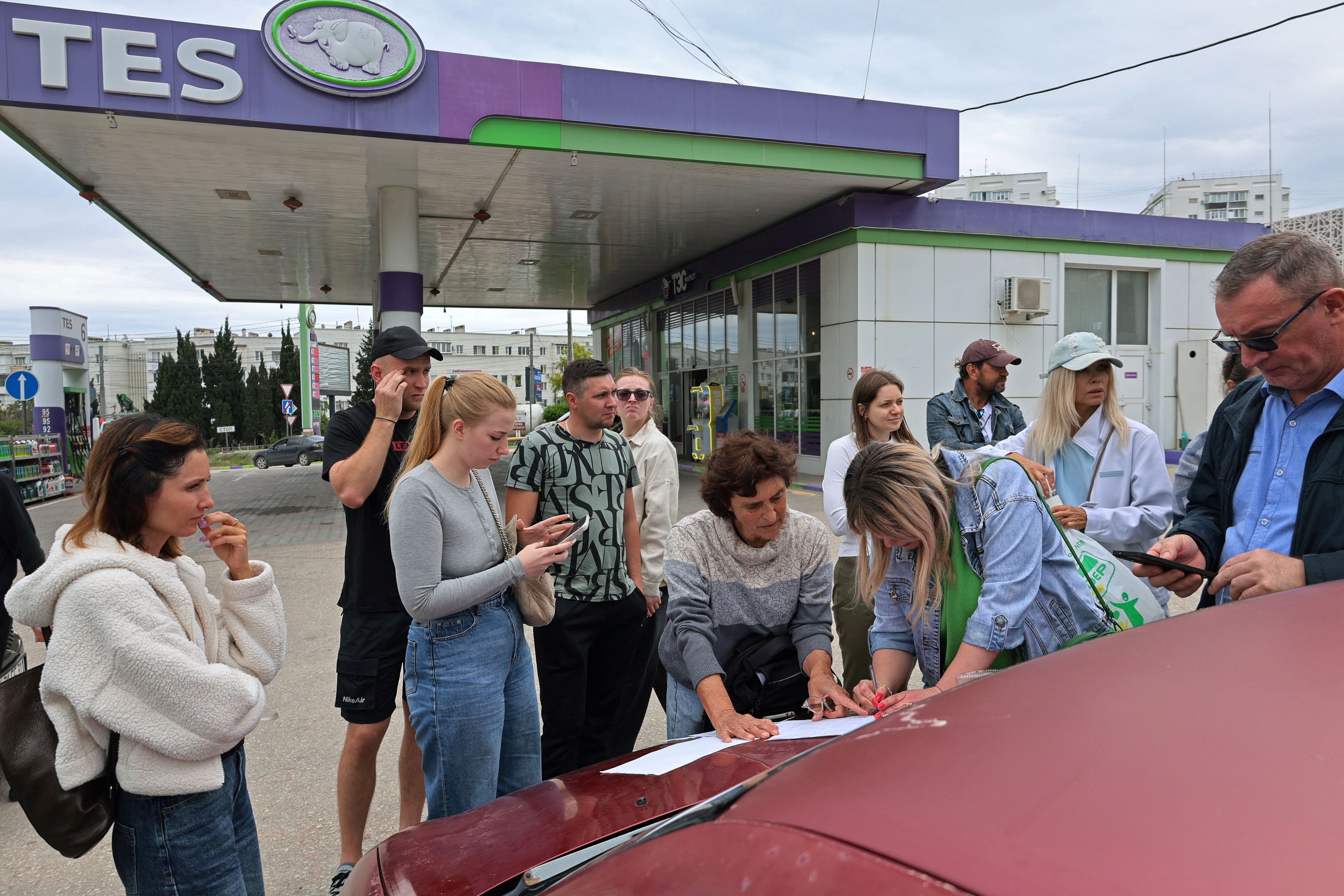 Die Situation ist prekär: Menschen in Sewastopol auf der Krim tragen sich in eine Warteliste für Kraftstoff an einer Tankstelle ein. Die Behörden haben den Verkauf aufgrund einer Versorgungsknappheit eingeschränkt. (1. Juni 2026)