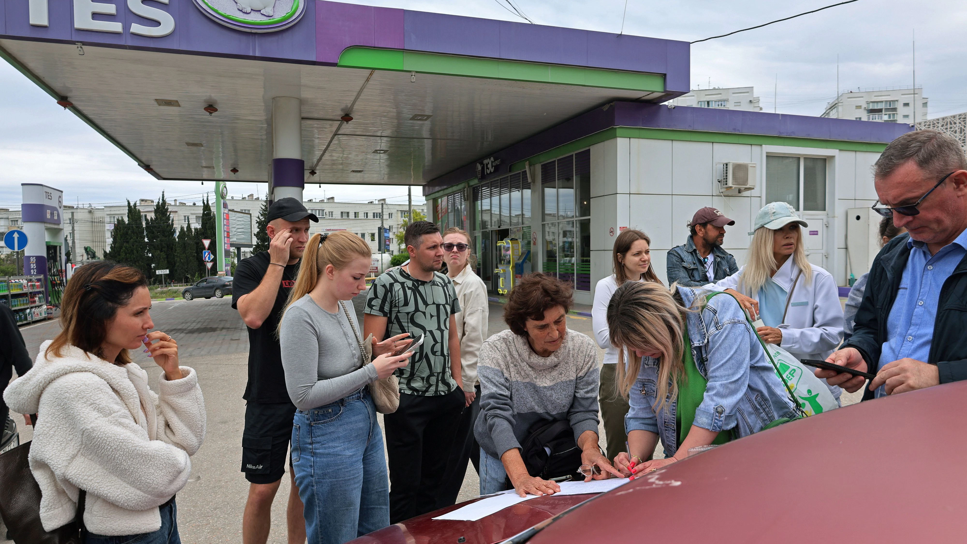 Die Situation ist prekär: Menschen in Sewastopol auf der Krim tragen sich in eine Warteliste für Kraftstoff an einer Tankstelle ein. Die Behörden haben den Verkauf aufgrund einer Versorgungsknappheit eingeschränkt. (1. Juni 2026)