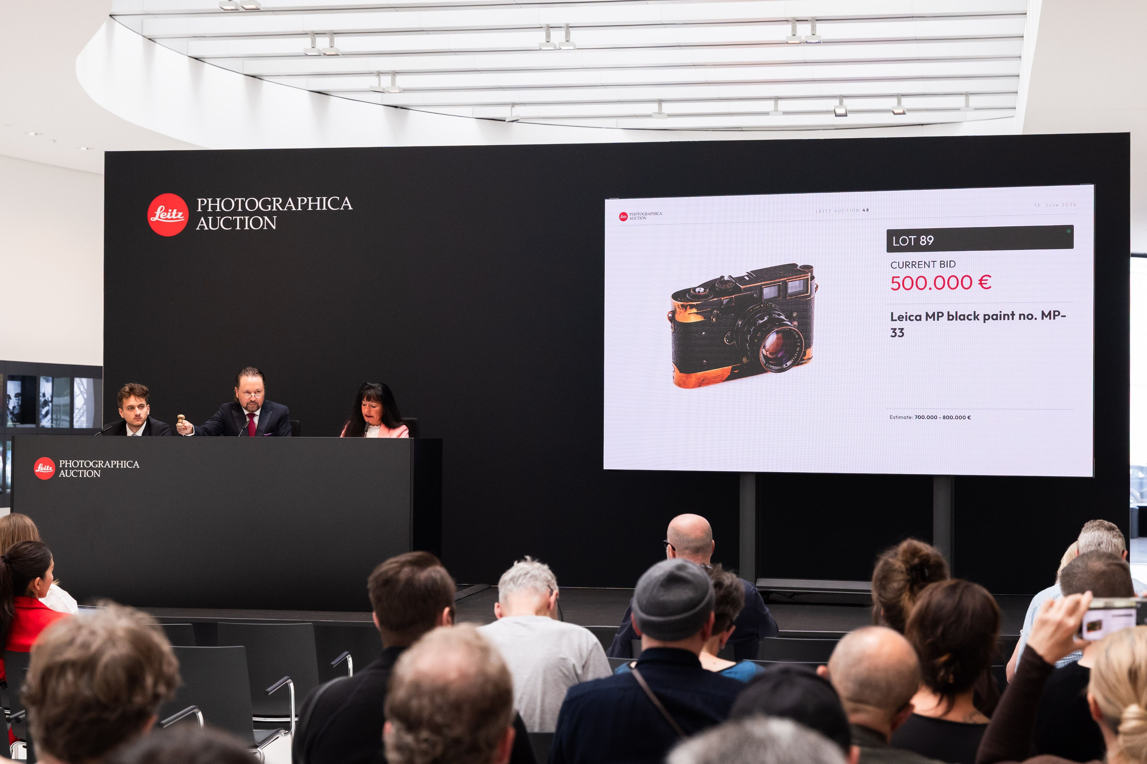 Auktionator Wolfgang Pauritsch (am Pult, Mitte) erteilt den Zuschlag für die Leica MP-33.
