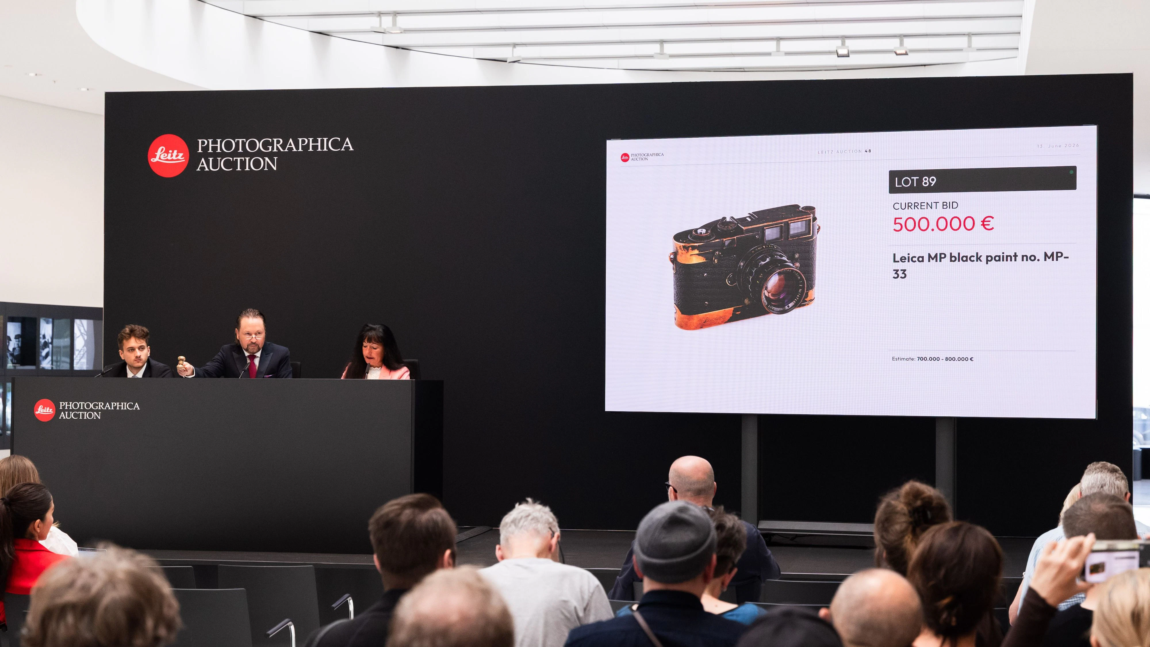 Auktionator Wolfgang Pauritsch (am Pult, Mitte) erteilt den Zuschlag für die Leica MP-33.