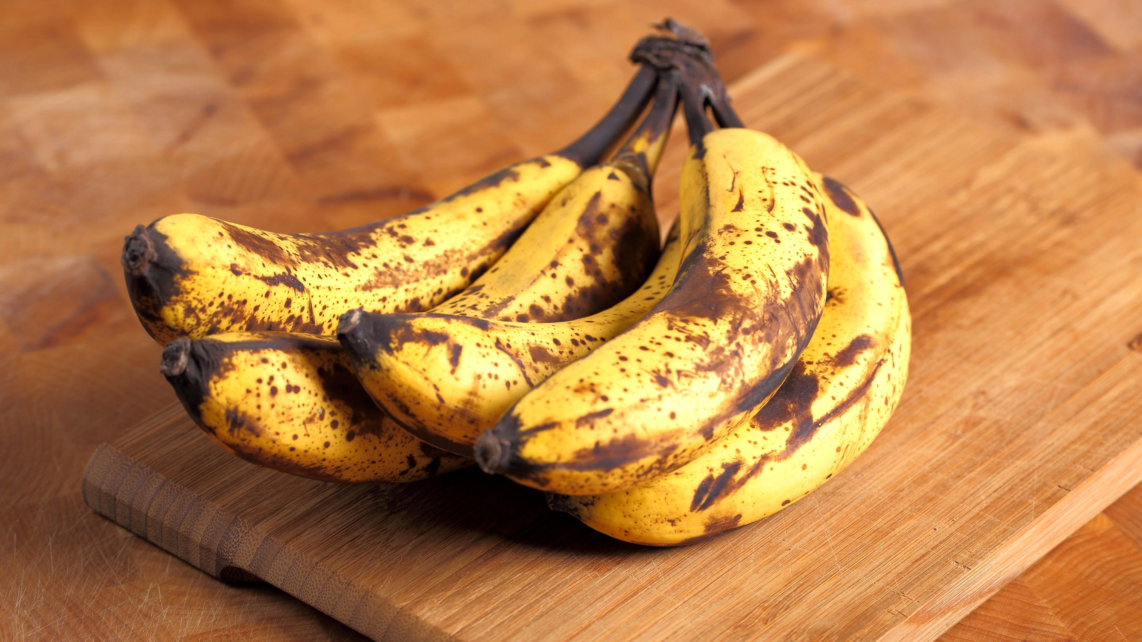 Bunch of overripe bananas on a wooden background